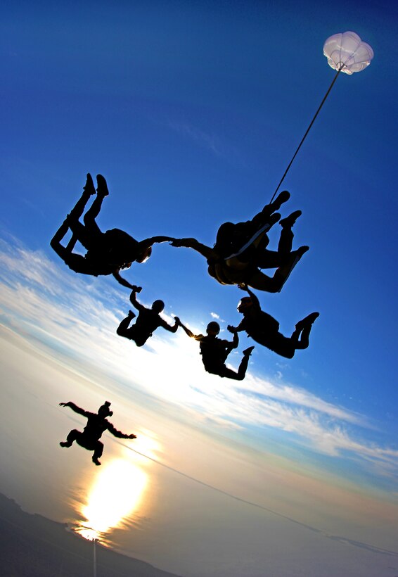 Members of the Vertical Formation Team, U.S. Army Parachute Team, Golden Knights, dock with a tandem skydive while training over Homestead Air Reserve Base, Fla., March 16, 2015.