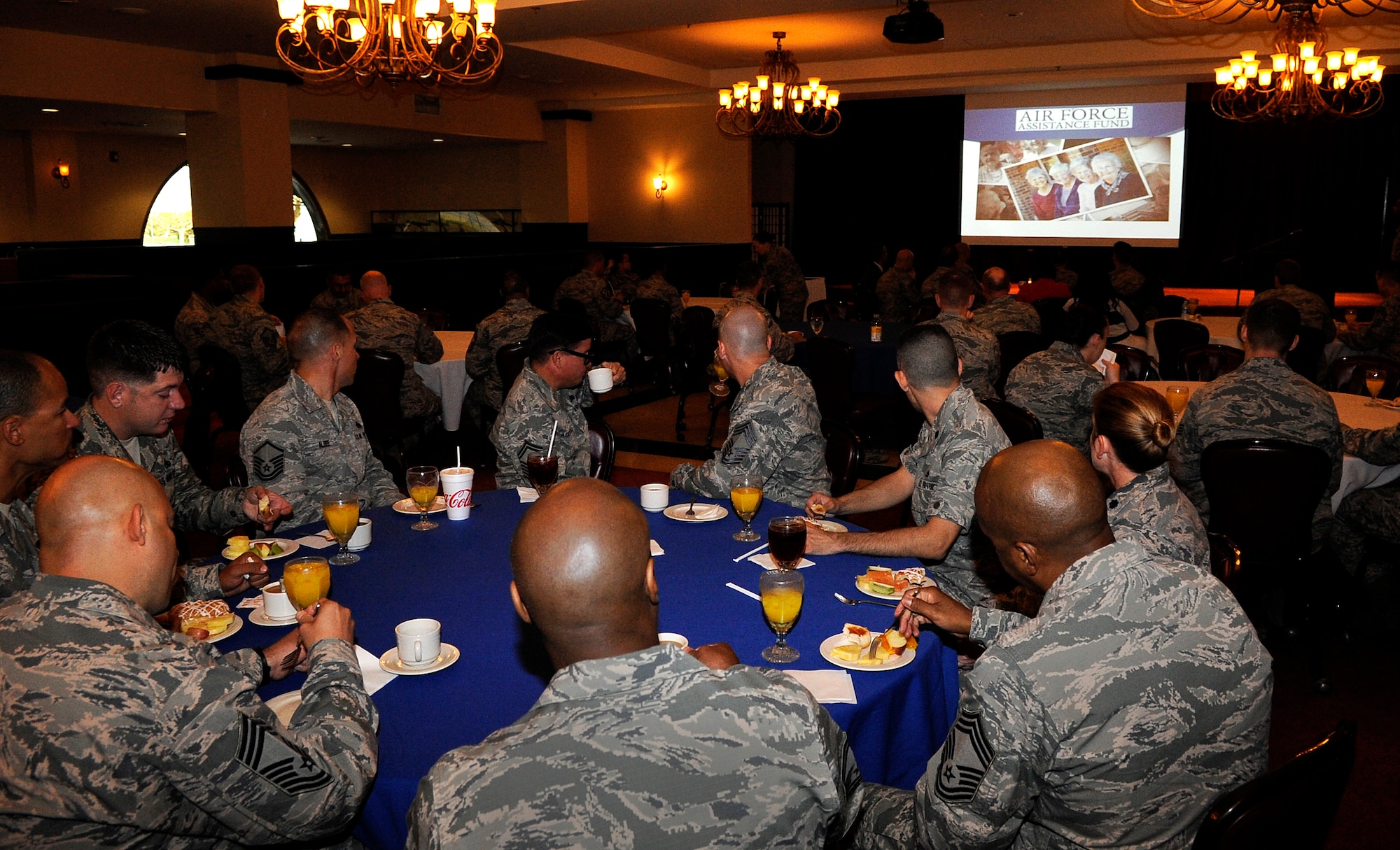 U.S. Air Force Airmen watch a video showing the four charities that the Air Force Assistance Fund goes to during the AFAF kick-off breakfast on Kadena Air Base, Japan, March 23, 2015. The four charities are the Air Force Aid Society, General and Mrs. Curtis E. LeMay Foundation, the Air Force Village, and the Air Force Enlisted Village. The charities are dedicated to caring for Airmen from induction through retirement and beyond. (U.S. Air Force photo by Staff Sgt. Marcus Morris)