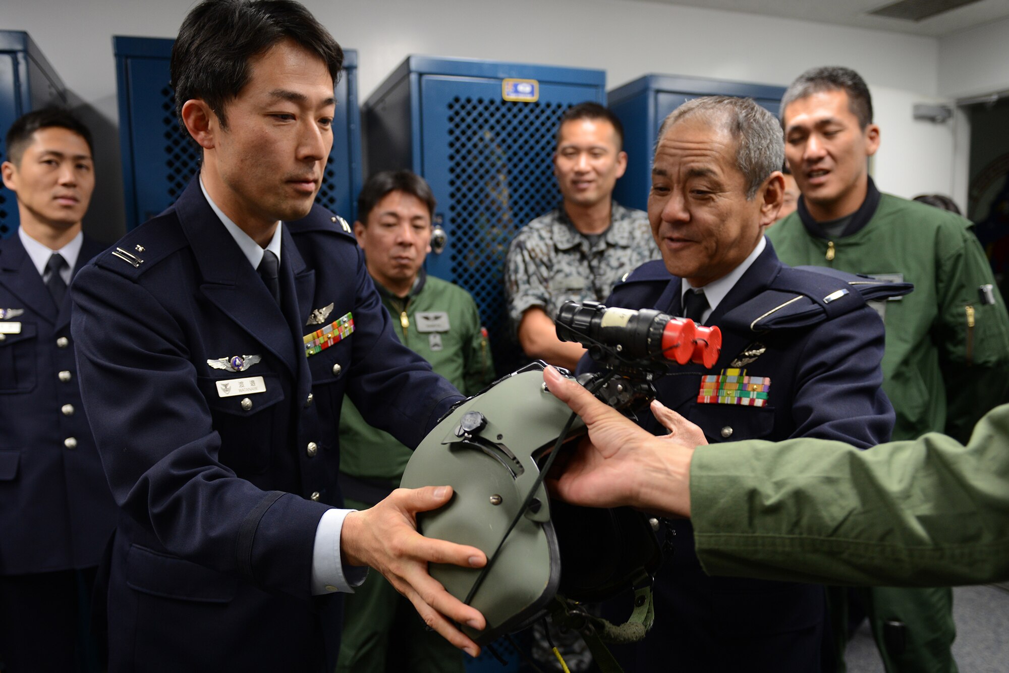 Japan Air Self-Defense Force personnel inspect a helicopter-aircrew helmet at Yokota Air Base, Japan, March 13, 2015. The helmet is equipped with night vision goggles used during night search and rescue operations. (U.S. Air Force photo by Airman 1st Class David C. Danford/Released)
