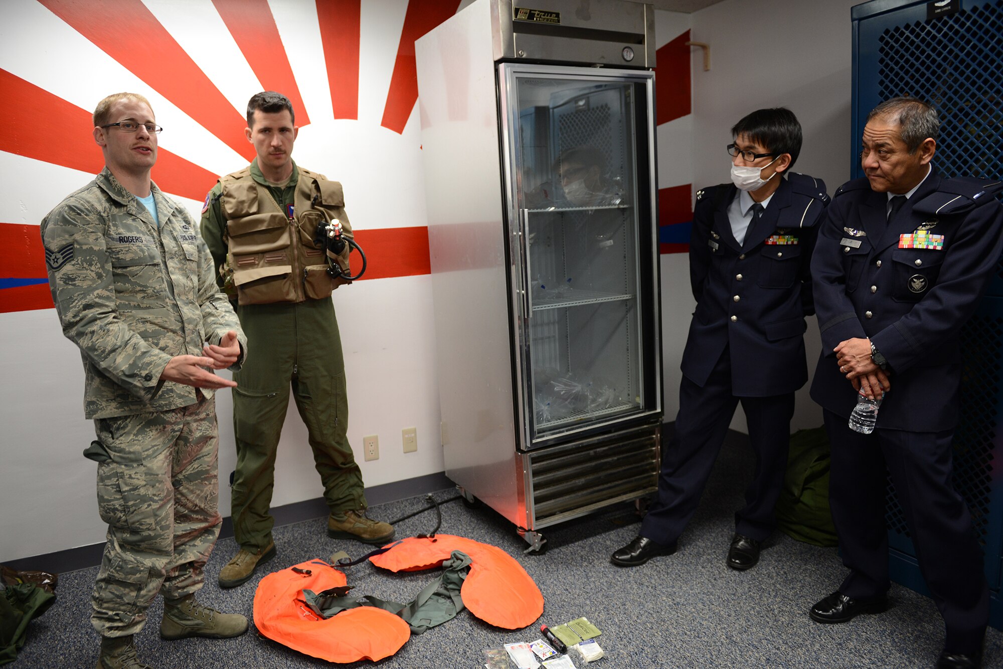 Staff Sgt. Robert Rogers, 374th Operations Support Squadron survival, evasion, resistance and escape training NCO in charge, briefs Japan Air Self-Defense Force personnel on the contents of a survival kit at Yokota Air Base, Japan, March 13, 2015. The kit contains flares, fire-starting materials and first-aid supplies. (U.S. Air Force photo by Airman 1st Class David C. Danford/Released)