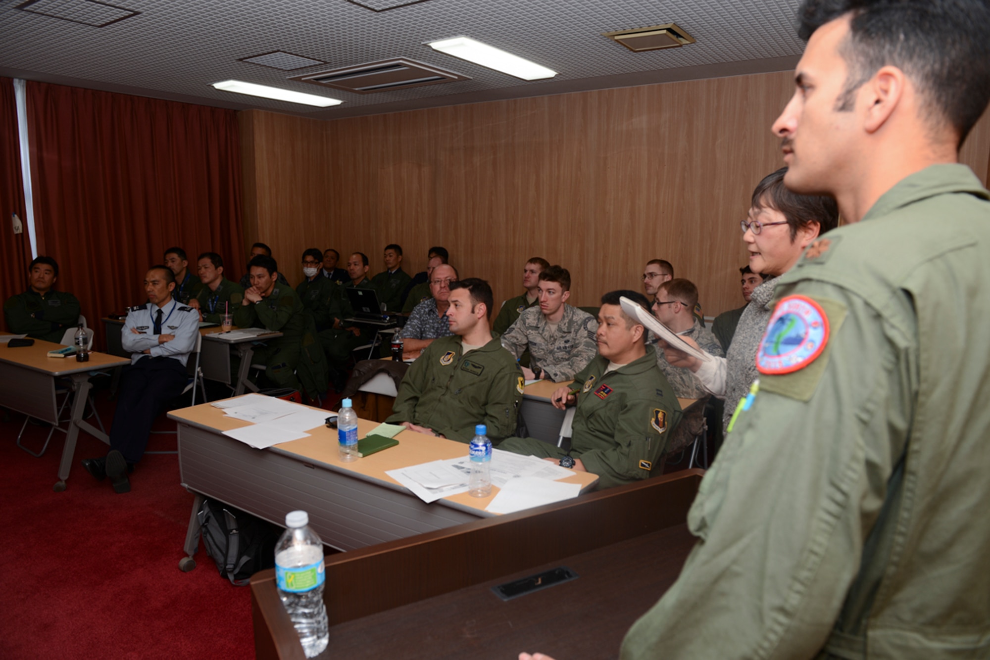 Maj. Nicholas Morris, 5th Air Force chief of rotary wing and personnel recovery operations, briefs Japan Air Self-Defense Force and U.S. Air Force members at Iruma Air Base, Japan, March 12, 2015. The briefing took place during a search and rescue conference held to promote cooperation between the JASDF and USAF. (U.S. Air Force photo by Airman 1st Class David C. Danford/Released)