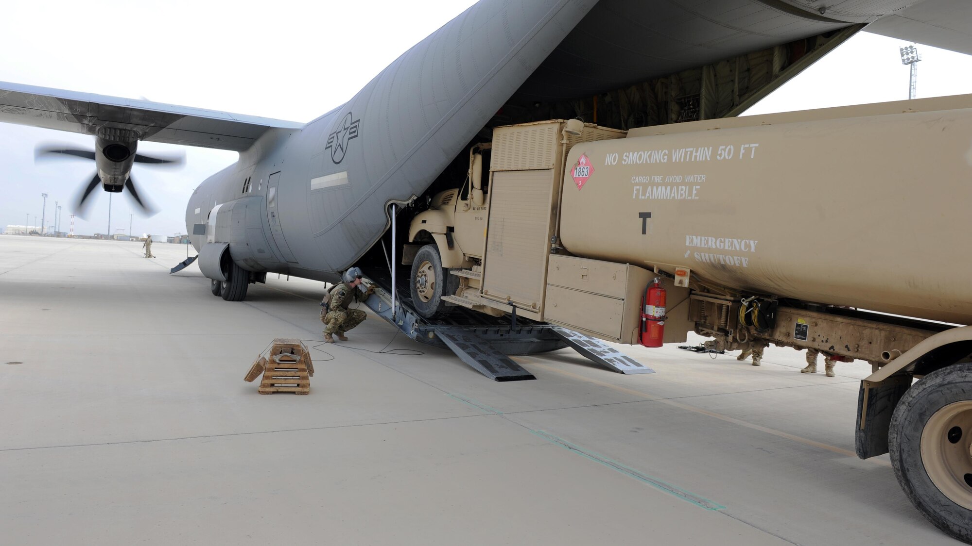 U.S. Air Force Lt. Col. Thomas Lankford, 774th Expeditionary Airlift Squadron commander, acts as a spotter as an R-11 fuel truck is loaded onto a C-130J Super Hercules aircraft during a redeployment mission at an undisclosed location in the Air Force Central Command area of responsibility March 15, 2015. The ability to forward deploy mission critical equipment, such as the R-11, to key sites throughout the AOR is more imperative than ever before as the Air Force reduces its footprint in the region. (U.S. Air Force photo by Staff Sgt. Whitney Amstutz)