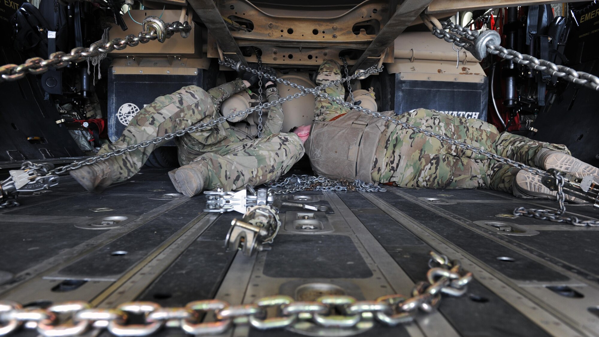 U.S. Air Force Senior Airman Kyle Bennett and Airman 1st Class Kelly Mahoney, 774th Expeditionary Airlift Squadron loadmasters, secure an R-11 fuel truck to the cargo compartment on a C-130J Super Hercules aircraft during a redeployment mission at an undisclosed location in the Air Force Central Command area of responsibility March 15, 2015. The ability to forward deploy mission critical equipment, such as the R-11, to key sites throughout the AOR is more imperative than ever before as the Air Force reduces its footprint in the region. (U.S. Air Force photo by Staff Sgt. Whitney Amstutz)