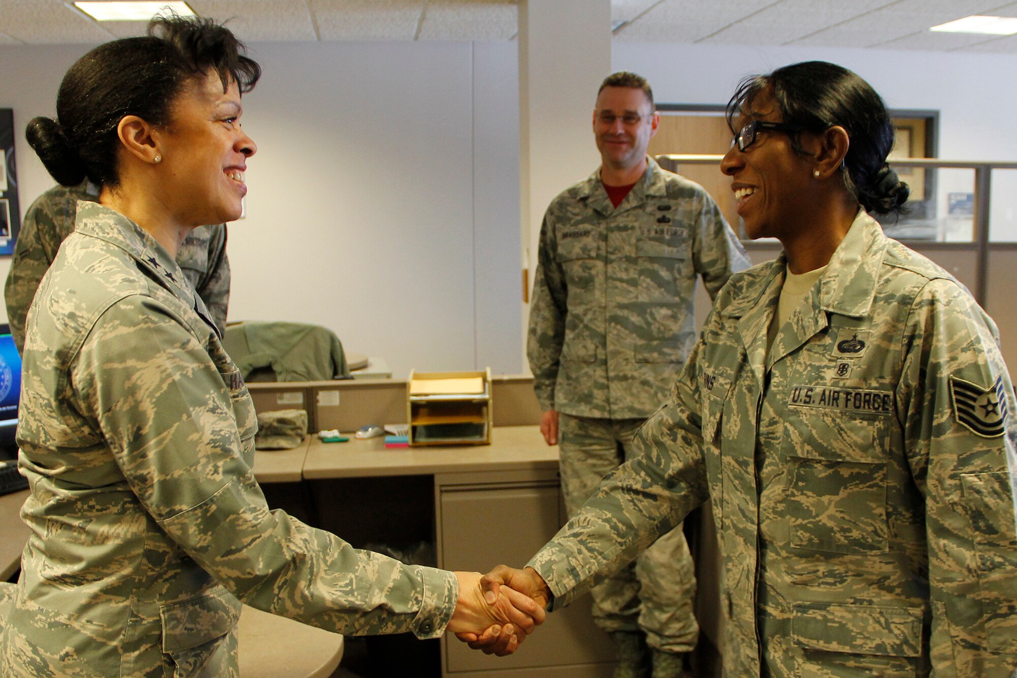Maj. Gen. Stayce D. Harris, 22nd Air Force commander, presents her commander’s recognition coin to Tech Sgt. Tonya Hagins, 302nd Force Support Squadron, Airman and Family Readiness noncommissioned officer in charge, on March 6, here. This is Harris’ first visit to the 302nd Airlift Wing since becoming commander of the 22nd Air Force in July 2014. (U.S. Air Force photo/Staff Sgt. Nathan Federico) 