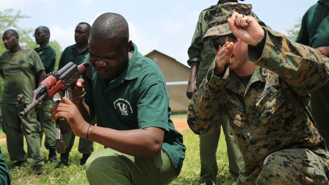 U.S. Marine Cpl. Joseph Kakascik, right, a rifleman and team leader assigned to Theater Security Cooperation team with Special-Purpose Marine Air-Ground Task Force Crisis Response-Africa, guides a Tanzanian park ranger through reload drills during a combat marksmanship class aboard the Selous Game Reserve in Matambwe, Tanzania, March 3, 2015. Kakascik was part of a team of Marines and Sailors who taught the park rangers proper weapons handling and combat marksmanship techniques. 