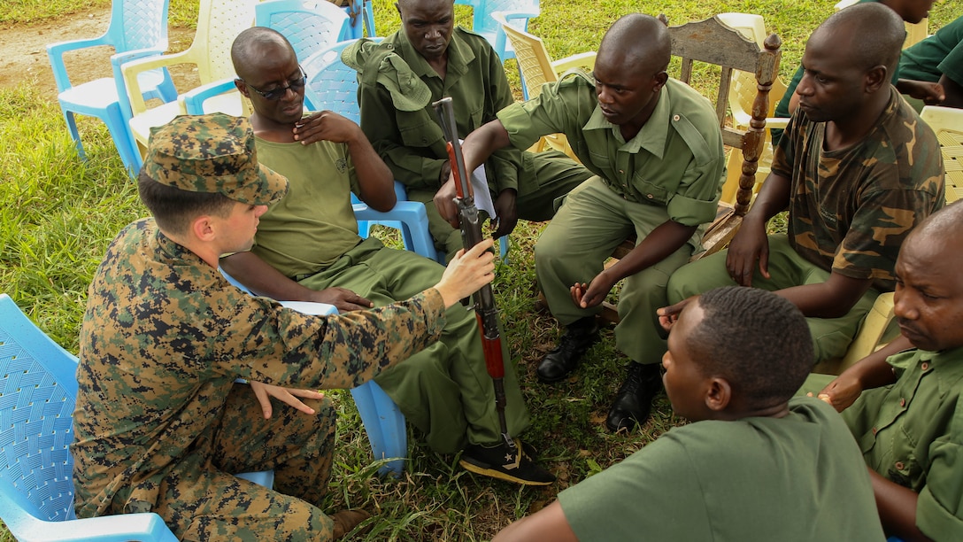 U.S. Marine 1st Lt. Nathaniel Kaine, left, the officer in charge of the Theater Security Cooperation team with Special-Purpose Marine Air-Ground Task Force Crisis Response-Africa, receives an AKM assault rifle from aTanzanian park ranger at the Selous Game Reserve in Matambwe, Tanzania, March 2, 2015. Kaine was one of more than 15 Marines and Sailors to help teach weapons safety and marksmanship techniques to the park rangers. 