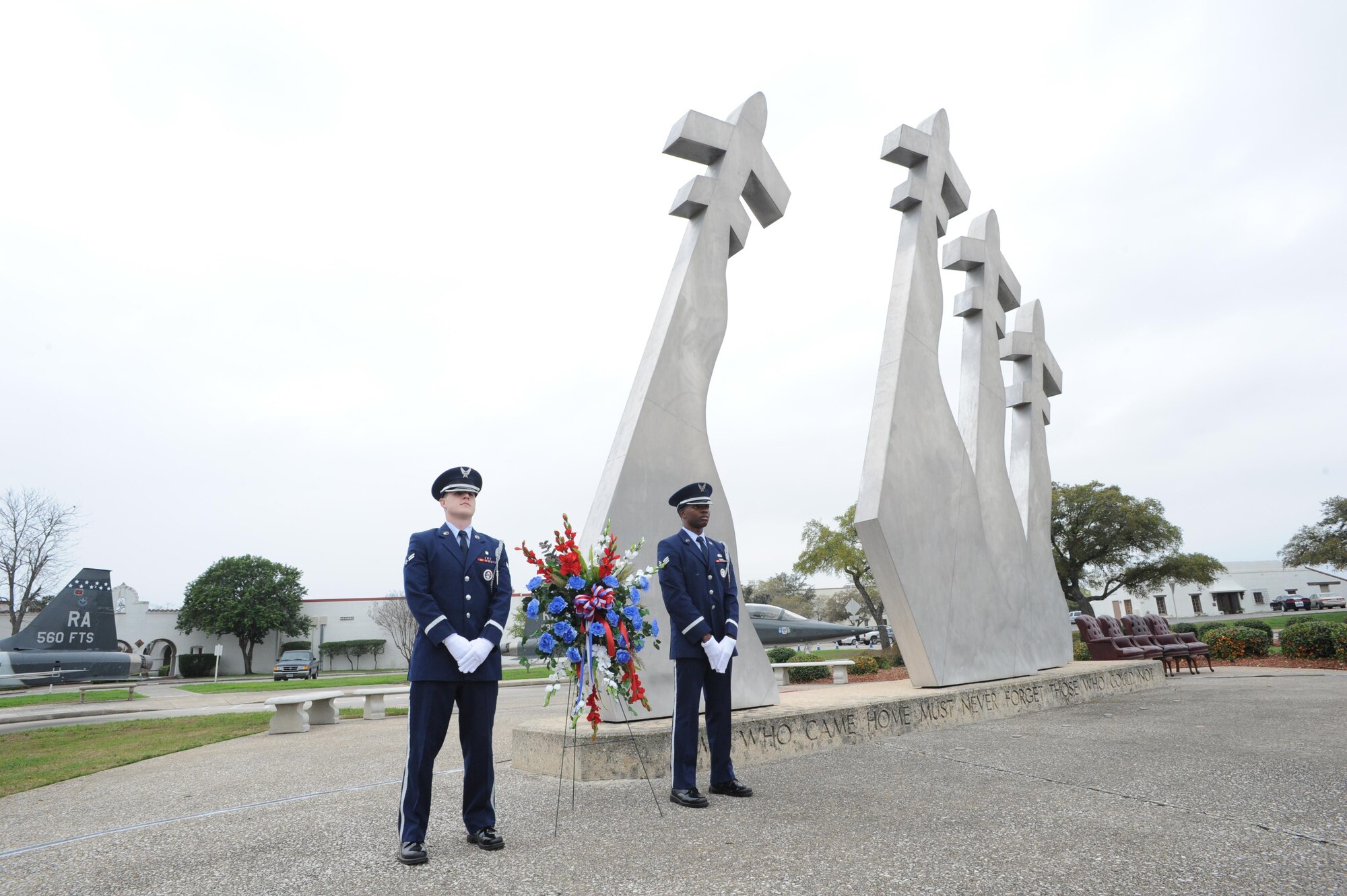 Airman 1st Class Hayden Tondee (left) and Senior Airman Willie Muhammad (right), Joint Base San Antonio Honor Guard members, stand at the Missing Man Memorial before the wreath laying ceremony, which was held in conjunction with the 42nd Freedom Flyer Reunion March 20 at JBSA-Randolph. (U.S. Air Photo by Melissa Peterson)