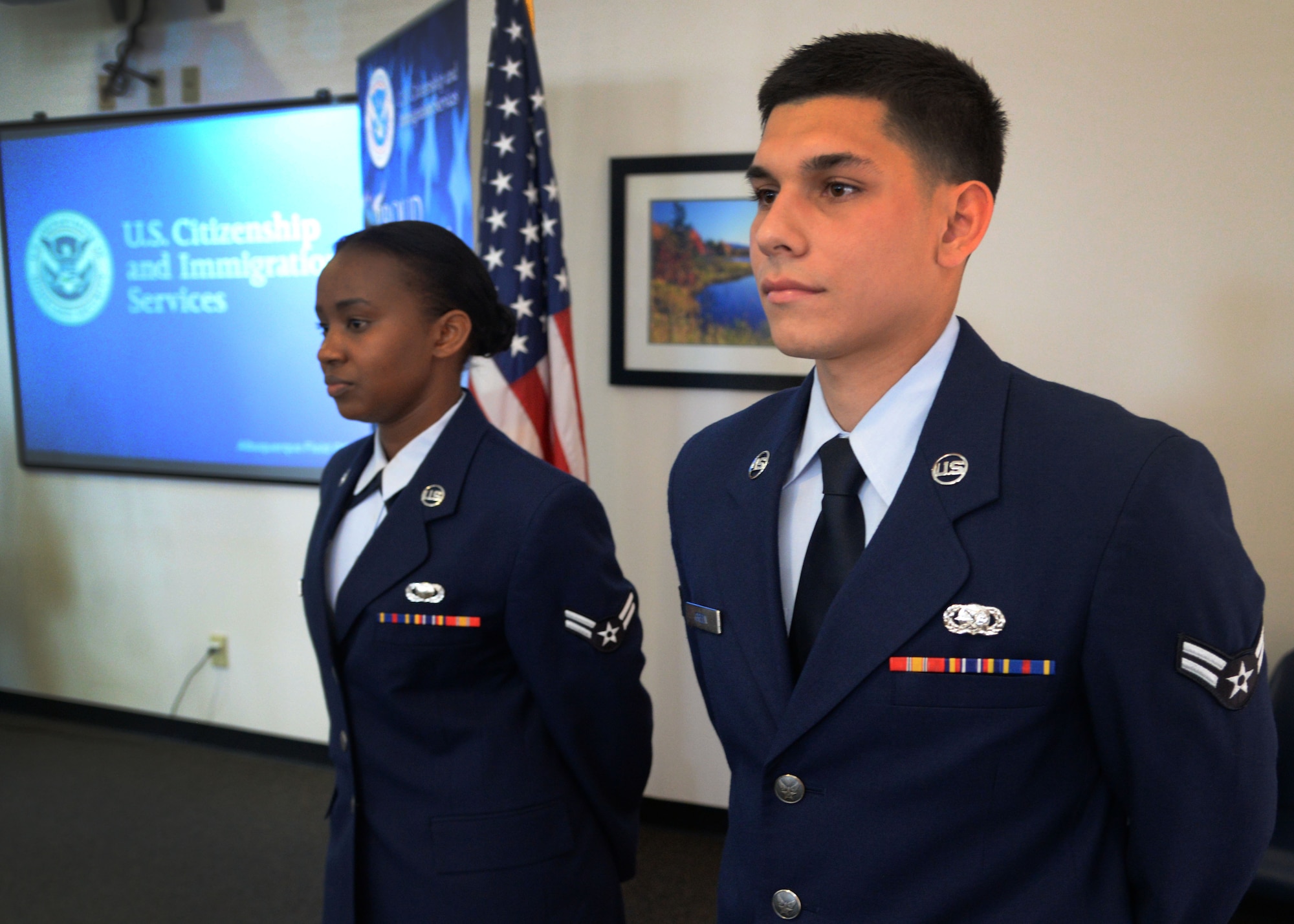U.S. Air Force Airman 1st Class Dominik Green, 27th Special Operations Logistics Readiness Squadron storage and issue specialist, and Airman 1st Class Rehema Mburugu, 27th Special Operations Contracting Squadron contract specialist, proudly stand in front of a room full of family and friends prior to a naturalization ceremony March 20, 2015 at Cannon Air Force Base, N.M. Green was born in Mannheim, Germany, Mburugu in Kenya, and were two of four presented with their citizenship after working several months with the United States Citizenship and Immigration Services field office in Albuquerque, New Mexico. (U.S. Air Force photo/Staff Sgt. Alex Mercer) 

