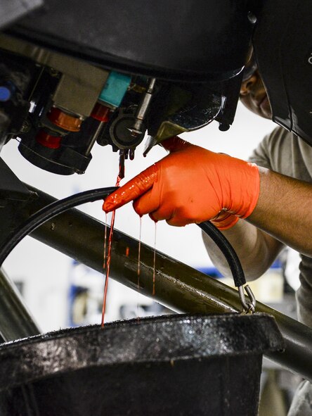 Airman 1st Class Roberto Diaz, 1st Special Operations Component Maintenance Squadron aerospace propulsion journeyman, empties hydraulic fluid from a propeller control pump housing at the Centralized Repair Facility, Hurlburt Field, Fla., Feb. 3, 2015. The Centralized Repair Facility is responsible for building and repairing T-56 engines and C-130 propellers. (U.S. Air Force photo Senior Airman Meagan Schutter/Released)