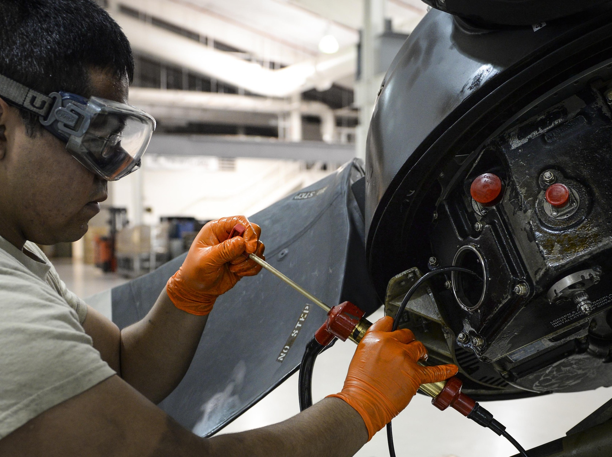 Airman 1st Class Roberto Diaz, 1st Special Operations Component Maintenance Squadron aerospace propulsion journeyman, empties hydraulic fluid from a valve housing on a propeller at the Centralized Repair Facility, Hurlburt Field, Fla., Feb. 3, 2015. The Centralized Repair Facility is responsible for building and repairing T-56 engines and C-130 propellers. (U.S. Air Force photo Senior Airman Meagan Schutter/Released)