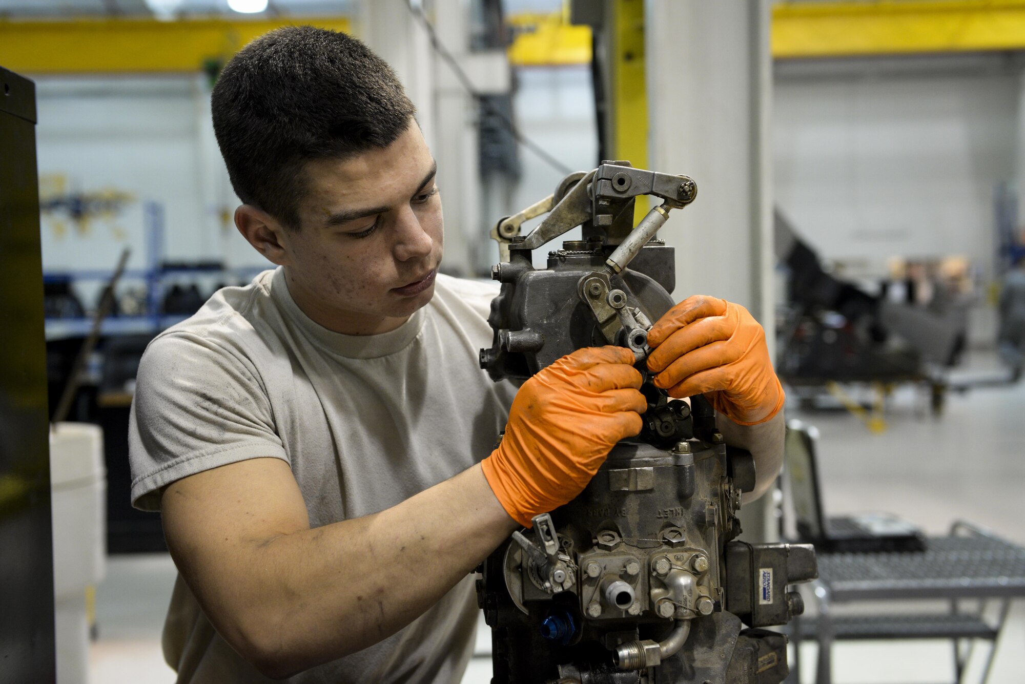 Airman 1st Class Nicholas Boho, 1st Special Operations Component Maintenance Squadron aerospace propulsion journeyman, installs a fuel control transfer rod on an engine at the Centralized Repair Facility, Hurlburt Field, Fla., Feb. 3, 2015. The Centralized Repair Facility is responsible for building and repairing T-56 engines and C-130 propellers. (U.S. Air Force photo Senior Airman Meagan Schutter/Released)