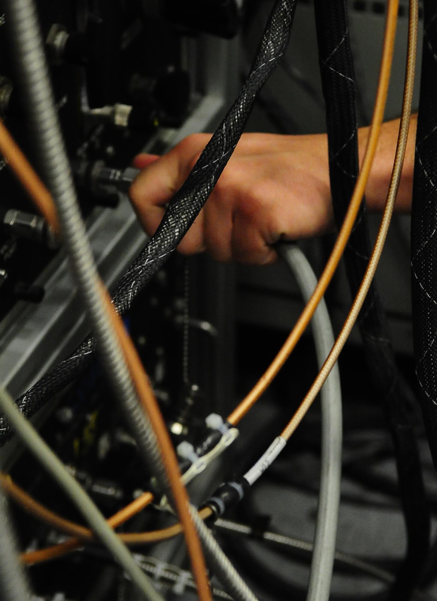 Senior Airman Nicholas Siegler, 1st Special Operations Component Maintenance Squadron journeyman mission systems avionics technician, connects signal wires to a transmitter test station at Hurlburt Field Fla., March 3, 2015. The 1st SOCMS provides command-wide, organizational and intermediate-level repair capability for a variety of aircraft. (U.S. Air Force photo/Airman 1st Class Andrea Posey)