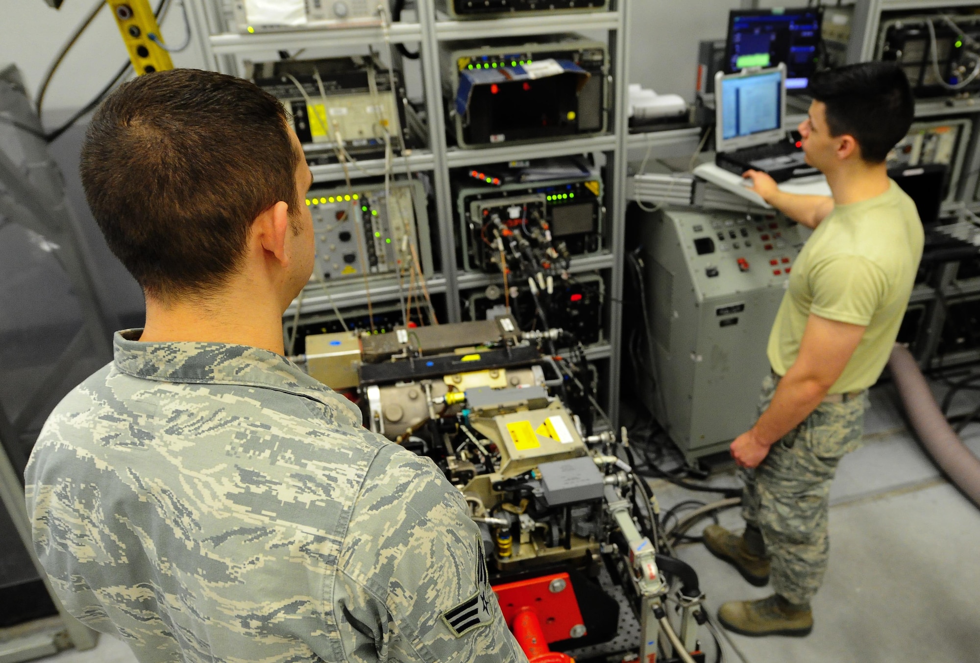 Senior Airman Nicholas Siegler, 1st Special Operations Component Maintenance Squadron journeyman mission systems avionics technician, and Airman 1st Class Matthew Takacs, 1st SOCMS apprentice mission systems avionics technician, trouble shoot a transmitter at Hurlburt Field Fla., March 3, 2015. The 1st SOCMS provides command-wide, organizational and intermediate-level repair capability for a variety of aircraft. (U.S. Air Force photo/Airman 1st Class Andrea Posey)