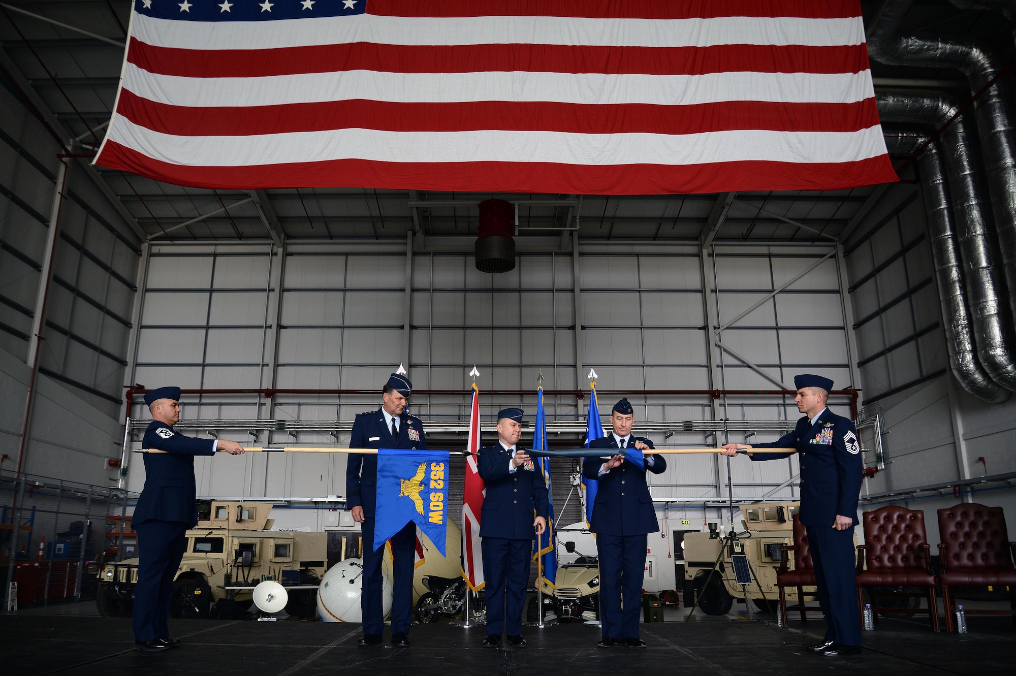 U.S. Air Force Lt. Gen. Brad A. Heithold, second from left, Air Force Special Operations Command commander, U.S. Air Force Col. William Holt, center, 352nd Special Operations Wing commander, and U.S. Air Force Lt. Col. Nathan Green, second from right, 752nd Special Operations Group commander, perform the 352nd SOW activation ceremony, March 23, 2015, on RAF Mildenhall, England. The 352nd SOW is responsible for planning and executing specialized and contingency operations using advanced aircraft, tactics and air refueling techniques to infiltrate, exfiltrate and resupply special operations forces.  (U.S. Air Force photo by Senior Airman Christine Griffiths)