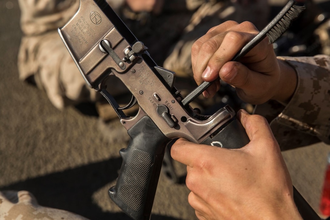 U.S. Marine Lance Cpl. Jared Marshall cleans the lower receiver to his M16A4 rifle aboard the USS Rushmore (LSD 47) during Composite Training Unit Exercise (COMPTUEX) off the coast of San Diego March 21, 2015. Marshall is a radio operator with Kilo Company, Battalion Landing Team 3rd Battalion, 1st Marine Regiment, 15th Marine Expeditionary Unit. While on ship, Marines focus on maintaining their weapons and combat skills. (U.S. Marine Corps photo by Sgt. Emmanuel Ramos/Released)