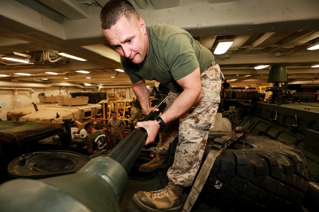U.S. Marine Gunnery Sgt. Dragos Coca performs maintenance on an LAV-25 Light Armored Vehicle  during Composite Training Unit Exercise (COMPTUEX) aboard the USS Anchorage (LPD 23) off the coast of San Diego March 20, 2015. Coca is an LAV commander with Battalion Landing Team 3rd Battalion, 1st Marine Regiment, 15th Marine Expeditionary Unit. The Marines and Sailors of the 15th MEU perform maintenance on their equipment to maintain combat readiness. (U.S. Marine Corps photo by Sgt. Jamean Berry/Released)