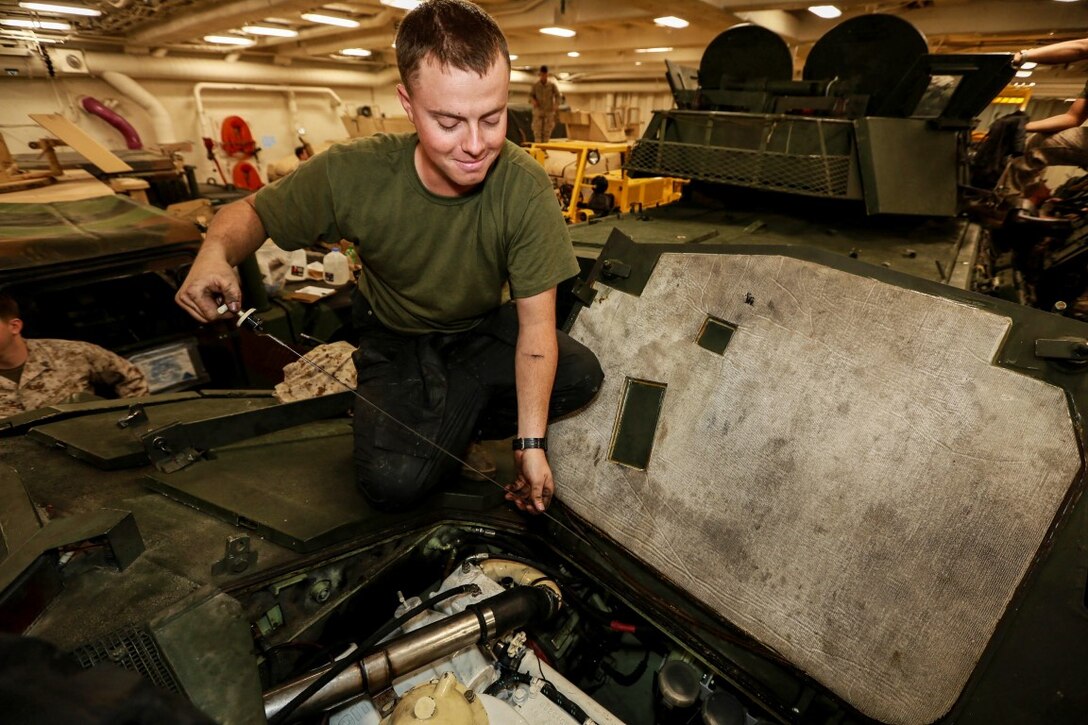 U.S. Marine Lance Cpl. Michael Littrell performs maintenance on an LAV-25 Light Armored Vehicle during Composite Training Unit Exercise (COMPTUEX) aboard the USS Anchorage (LPD 23) off the coast of San Diego March 20, 2015. Littrell is an LAV driver with Battalion Landing Team 3rd Battalion, 1st Marine Regiment, 15th Marine Expeditionary Unit. The Marines and Sailors of the 15th MEU perform maintenance on their equipment to maintain combat readiness.  (U.S. Marine Corps photo by Sgt. Jamean Berry/Released)
