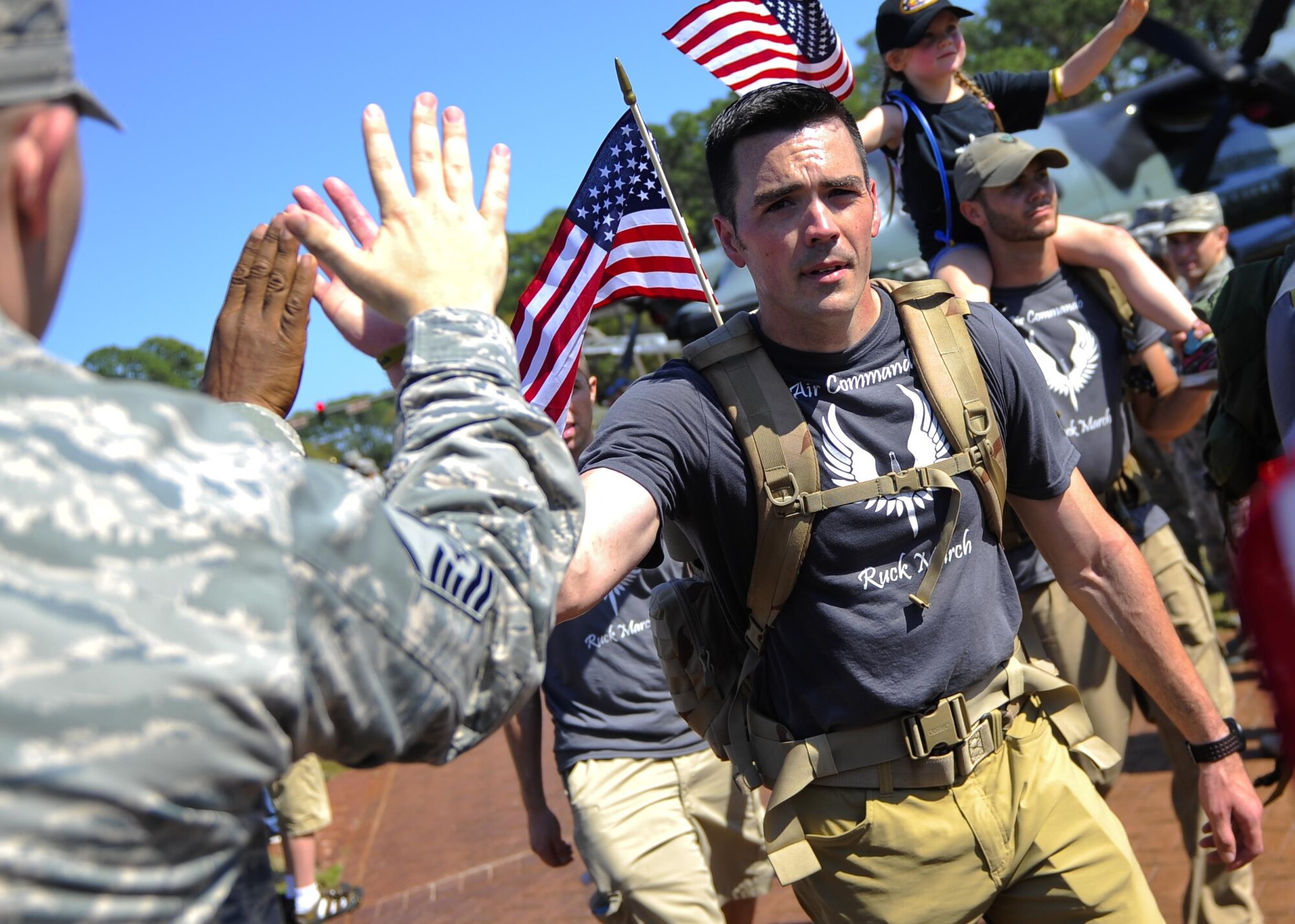 Tech. Sgt. Michael Dylan, 18th Flight Test Squadron, gives a high five at the end of a 450 mile ruck march that began at MacDill Air Force Base, Fla., on March 15, 2015 and ended at Hurlburt Field, Fla., March 20, 2015. The 11 Air Commandos carried flags with the names of the seven fallen Special Operations Command members and four Army National Guard air crew members that lost their lives during a training mission, March 10, 2015. (U.S. Air Force photo/Senior Airman Christopher Callaway/Released)