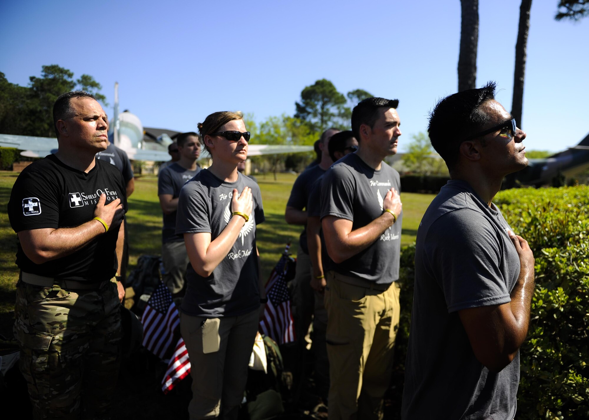 Air Force Special Operations Command Airmen pay their respects during the National Anthem at Hurlburt Field, Fla., March 20, 2015. Eleven Air Commandos carried flags with the names of the seven fallen Special Operations Command Marines and four Army National Guard air crew members during a 450-mile ruck march from MacDill Air Force Base, Fla., to Hurlburt Field.