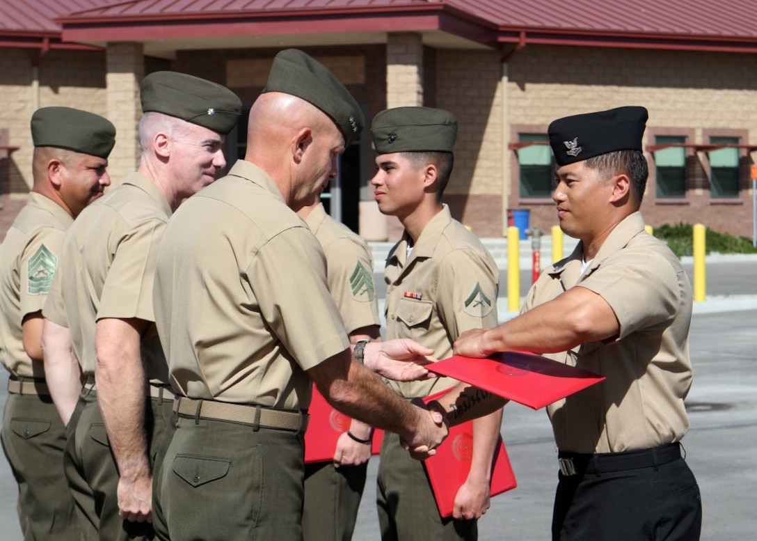 Lt. Gen. David H. Berger, commanding general, I Marine Expeditionary Force, Lt. Col. Brian Russell, commanding officer, 1st Air Naval Gunfire Liaison Company and Master Sgt. Oscar Luna, operations chief, 1st ANGLICO present diplomas to the graduates of the ANGLICO Basic Course aboard Camp Pendleton, Calif., March 20, 2015. Marines with 1st and 6th ANGLICO attended the three-week ANGLICO Basic Course, a three-section course implementing the basics of motor transportation, communications and call-for-fire techniques.