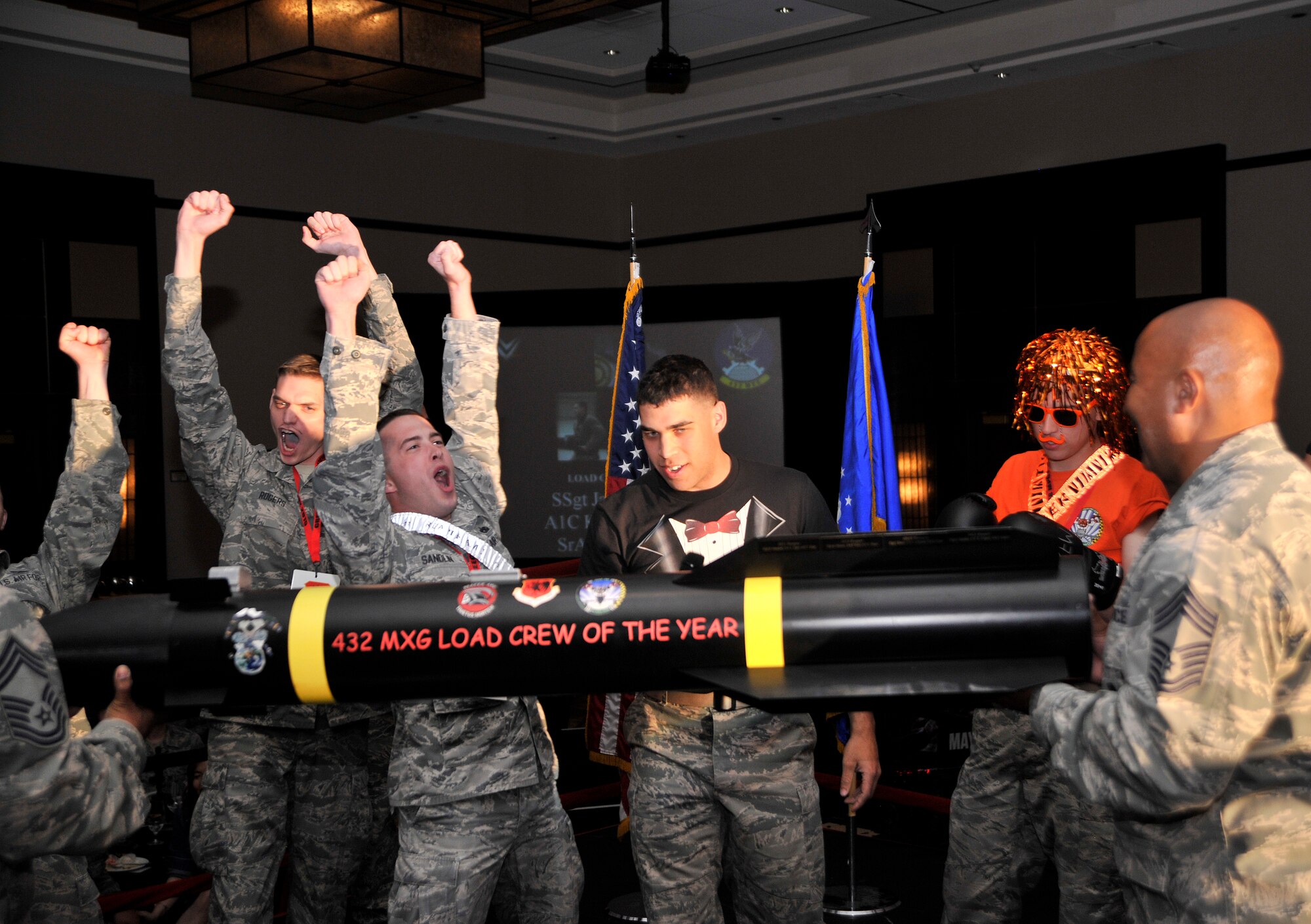 The Reaper Aircraft Maintenance Unit, left, celebrates after being announced the winners of the 2014 432nd Maintenance Group Load Crew of the Year competition during the 432nd MXG Maintenance Professional of the Year ceremony March 20, 2015, at the Aliante Hotel and Casino, Las Vegas. Reaper AMU is assigned to the 432nd Aircraft Maintenance Squadron located on Creech Air Force Base, Nevada, and maintains the MQ-9 Reaper remotely piloted aircraft. (U.S. Air Force photo by Airman 1st Class Christian Clausen/Released) 