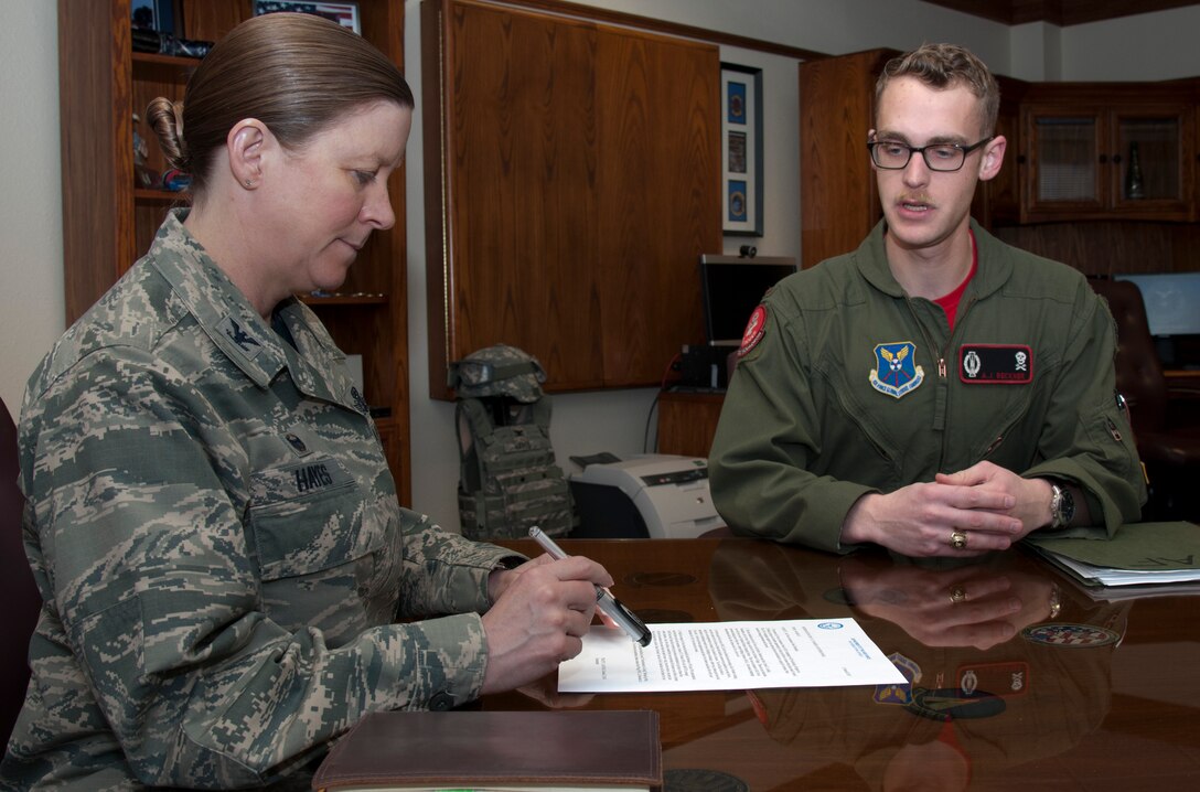 Col. Tracey Hayes, 90th Missile Wing commander, and 2nd Lt. Andrew Beckner, 320th Missile Squadron combat crew commander, read over the Air Force Assistance Fund memorandum for the wing March 13, 2015, in Hayes’ office. This year’s campaign goal is to raise more than $49,000. (U.S. Air Force photo by Airman 1st Class Malcolm Mayfield)   