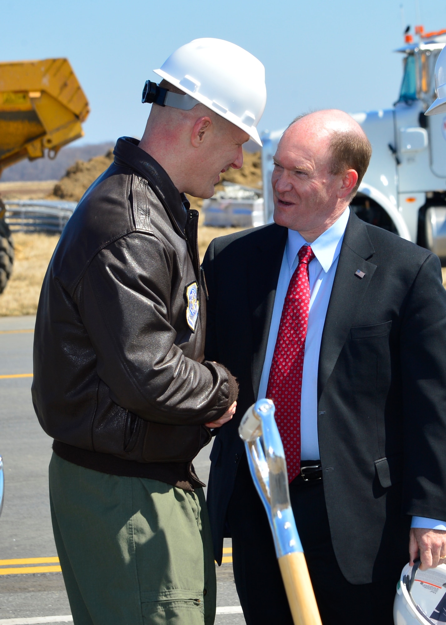 Col. Michael Grismer, 436th Airlift Wing commander, shakes hands with Sen. Chris Coons, D-Del., March 23, 2015, at Dover Air Force Base, Del. Coons and other Congressional leaders attended a Runway Repair Groundbreaking ceremony in support of the $98.3 million renovation project to runway 01-19. (U.S. Air Force photo/Airman 1st Class William Johnson)