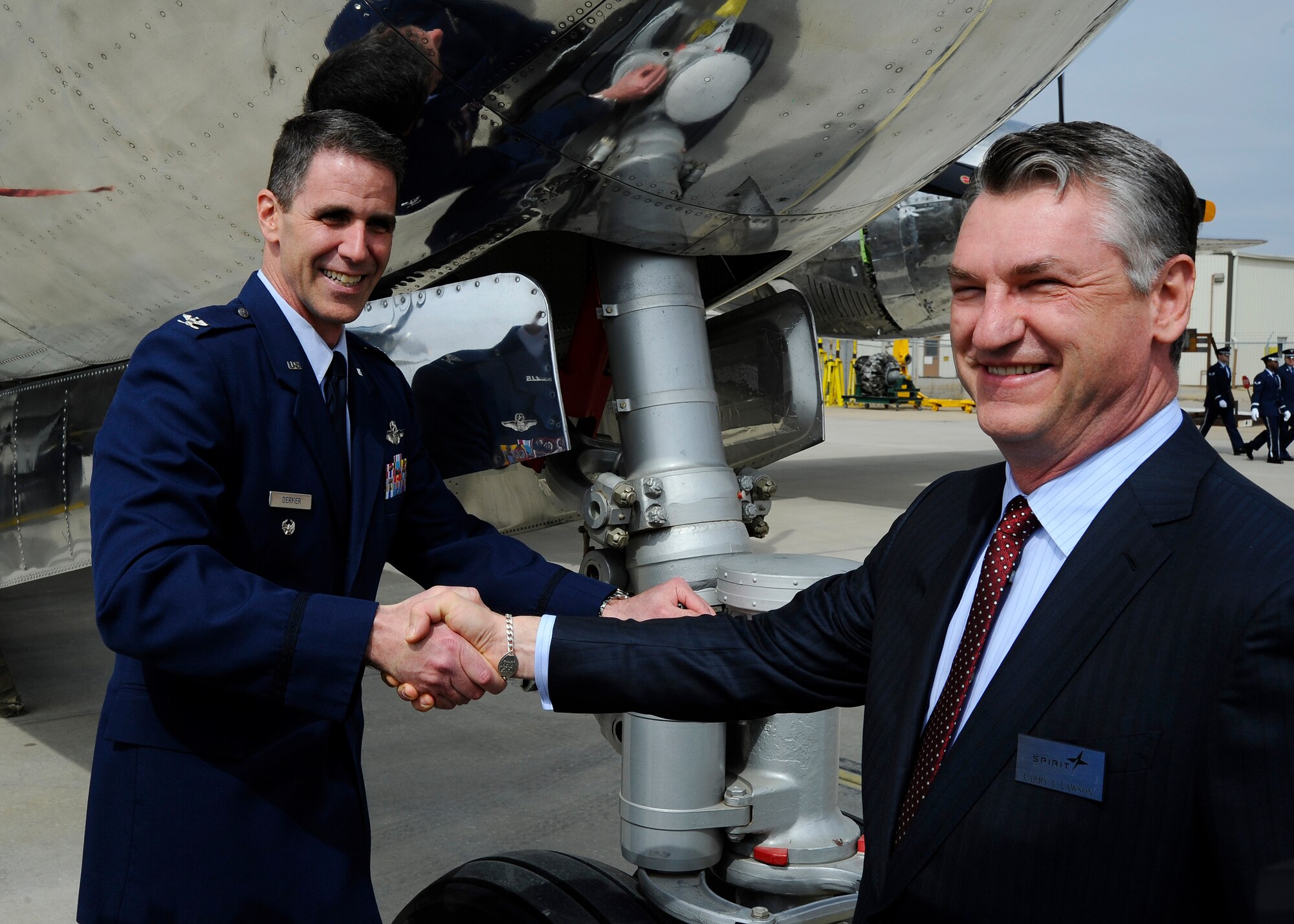 Col. James Dermer, 22nd Air Refueling Wing vice commander, poses with Larry Lawson, Spirit AeroSystems CEO and president, under the nose of a B-29 Superfortress, March 23, 2015, in Wichita, Kan. The B-29, named Doc after its nose art, was found in the Mojave Desert in 1987, and volunteers have spent more than 300,000 hours restoring it since then. (U.S. Air Force photo by Senior Airman Victor J. Caputo)