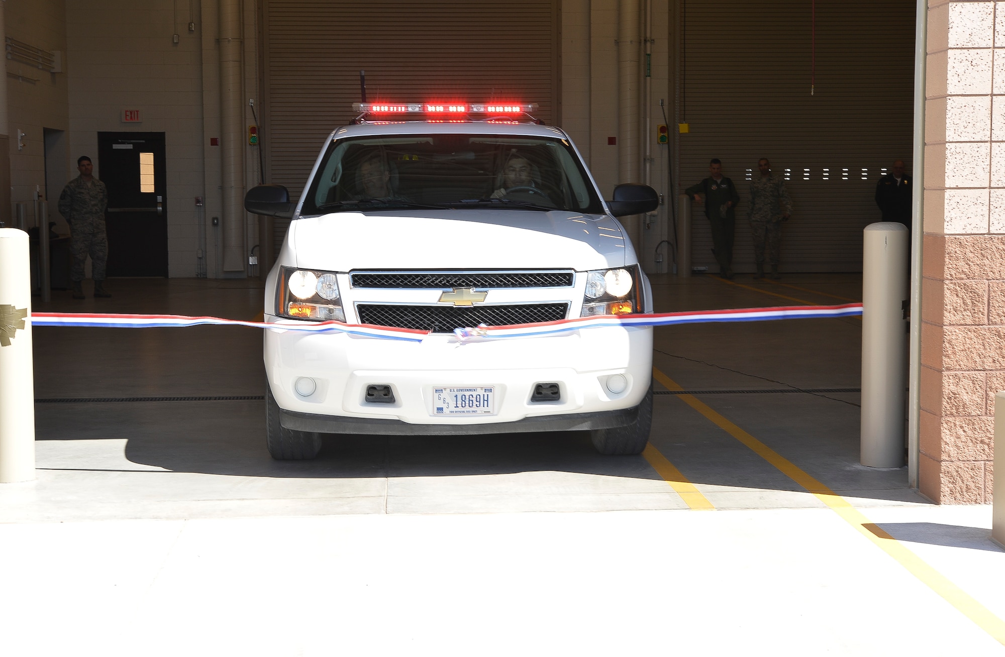 U.S. Air Force Gen. Hawk Carlisle, commander of Air Combat Command, left, and John Beauchamp, Nellis-Creech Fire Emergency Services fire chief, drive a truck to break the ribbon during a ceremony for the new Fire Station 6 on March 4, 2015, at Creech Air Force Base, Nevada. The new fire house provides a location for fire trucks and firefighters to quickly respond to the growing northern portion of the base. (U.S. Air Force photo by Senior Airman Adarius Petty/Released)