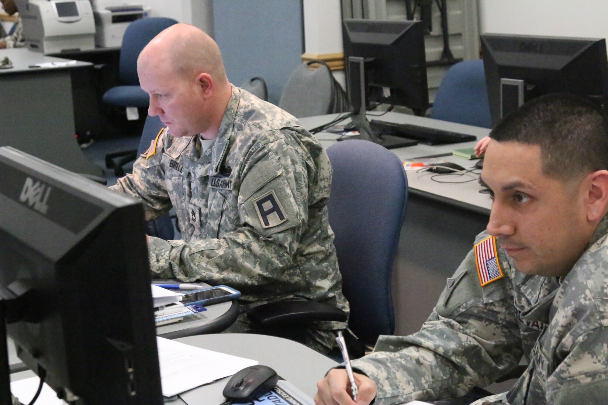Army Sgts. 1st Class Brent Brell and Henry Arevalo, Headquarters 174th Infantry Brigade, coordinate on a practical exercise during this month's Battle Staff Noncommissioned Officers Course held at Army Support Activity Dix Distance Learning Center on Joint Base McGuire-Dix-Lakehurst, N.J., March 1-31, 2015. (U.S. Army photo by Maj. Antonia Greene-Edwards/Released)
