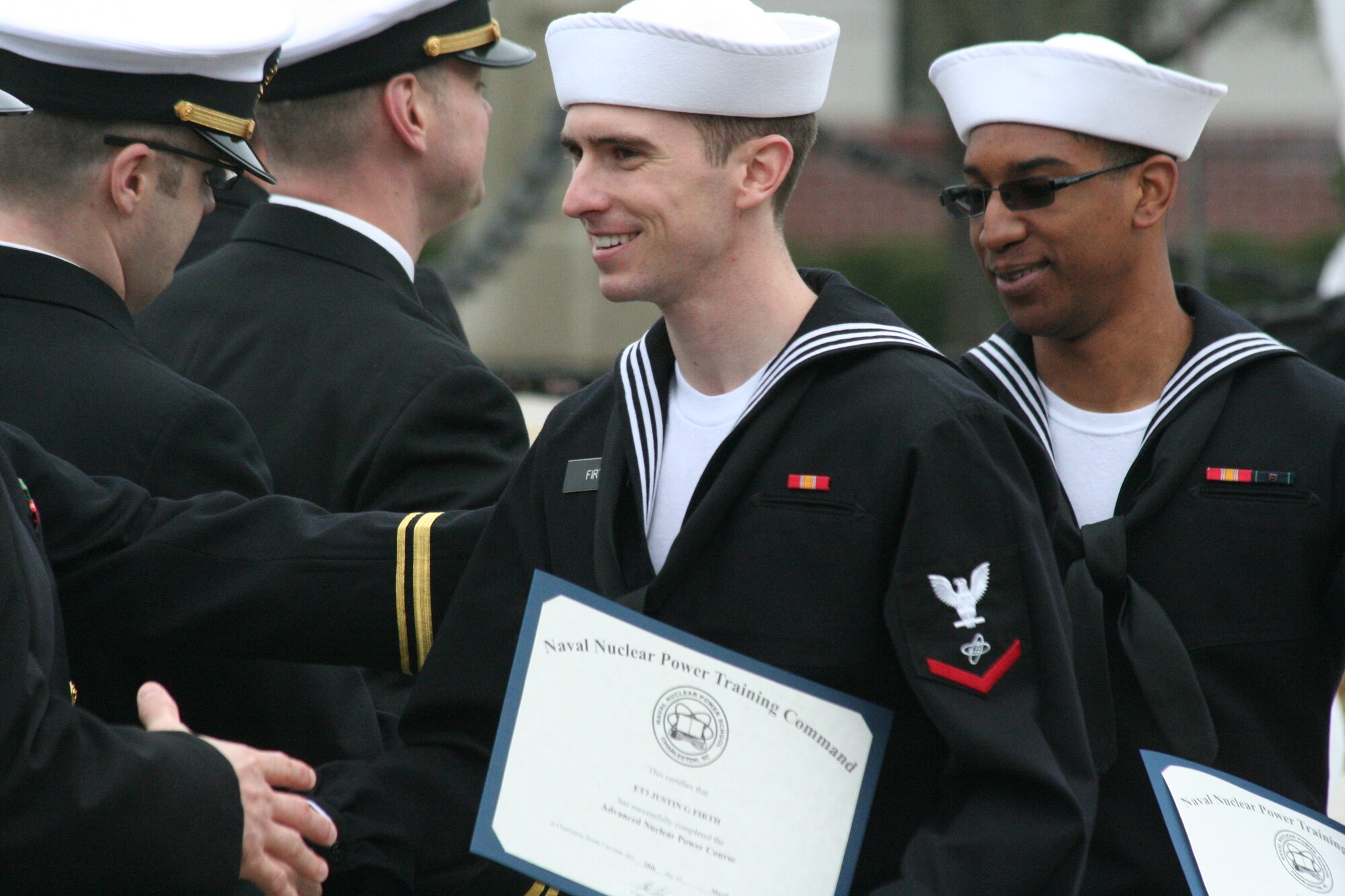 Electronics Technician 3rd Class Justin Firth shakes hands with a former instructor during the Nuclear Power School Class 1407 graduation ceremony on March 20 in Goose Creek, SC. More than 1,200 Naval Nuclear Power Training Command staff members, students, family and friends gathered to honor the class before their transition to future duty stations. (US Navy photo by Electrician’s Mate 3rd Class Jett Supler)