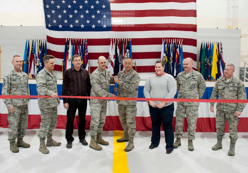Col. Patrick Butler, 5th Maintenance Group commander, and Maj. Mark Chapa, 5th Maintenance Squadron commander, are joined by other base leadership in a ribbon cutting ceremony to commemorate the grand opening of Dock 8 on Minot Air Force Base, N.D., March 18, 2015. The 80,000 square foot double hangar has the capacity to hold two B-52H Stratofortresses fully enclosed and is energy efficient. (U.S. Air Force photo/Airman 1st Class Sahara L. Fales)
