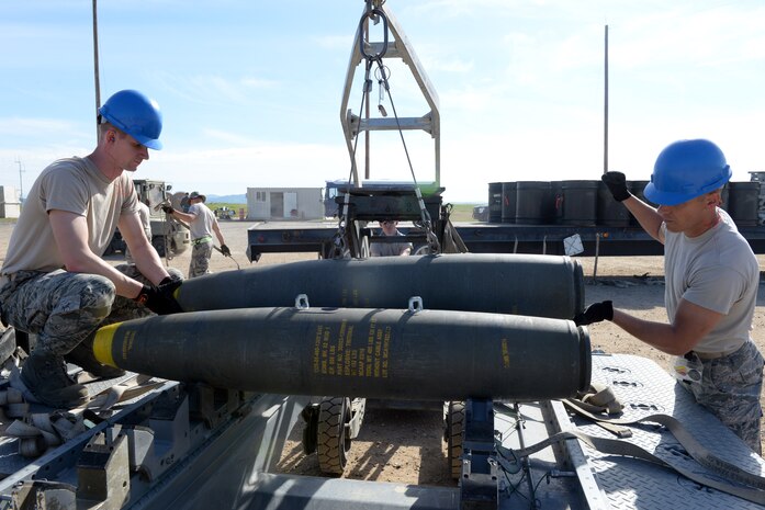 Airmen lower ammunition at a munition pad on Beale Air Force Base, Calif., March 17, 2015. The Airmen were attending the Combat Ammunition Planning and Production course, which is an upgrade requirement for all 2W0 munitions system personnel. (U.S. Air Force photo by Senior Airman Bobby Cummings/Released)