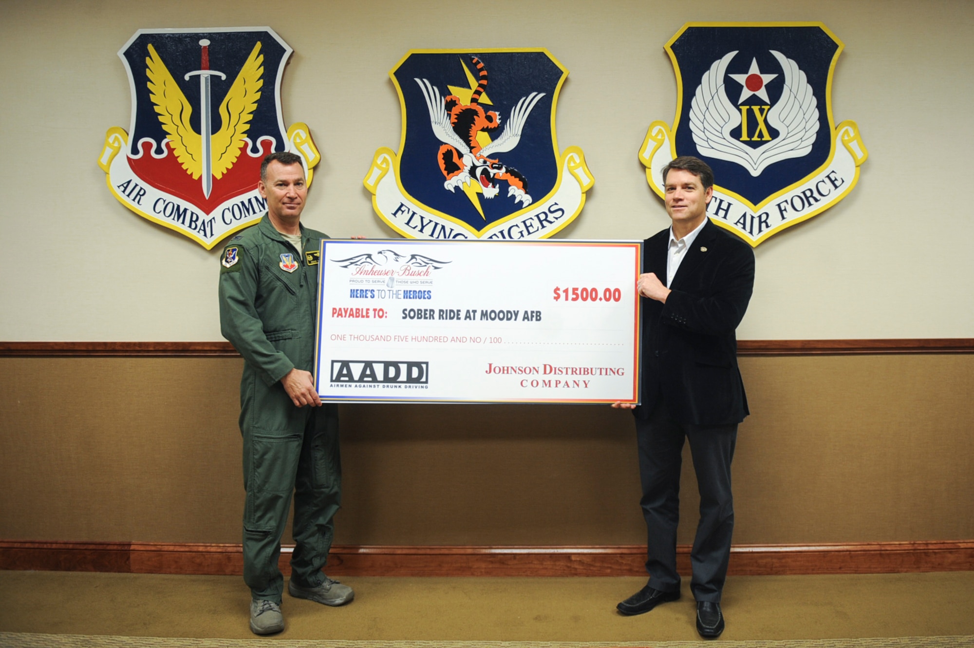 Tim Keller, Johnson Distributing Company consumer awareness and education, presents a check to U.S. Air Force Col. Chad Franks, 23d Wing commander, for the Airman Against Drunk Driving (AADD) program March 23, 2015 at Moody Air Force Base, Ga. Previously known as ‘Sober Ride,’ AADD is a volunteer program that is designed to help Airmen return home safely after a night out. The donation will fund future AADD events. (U.S. Air Force photo by Senior Airman Olivia Bumpers/Released)