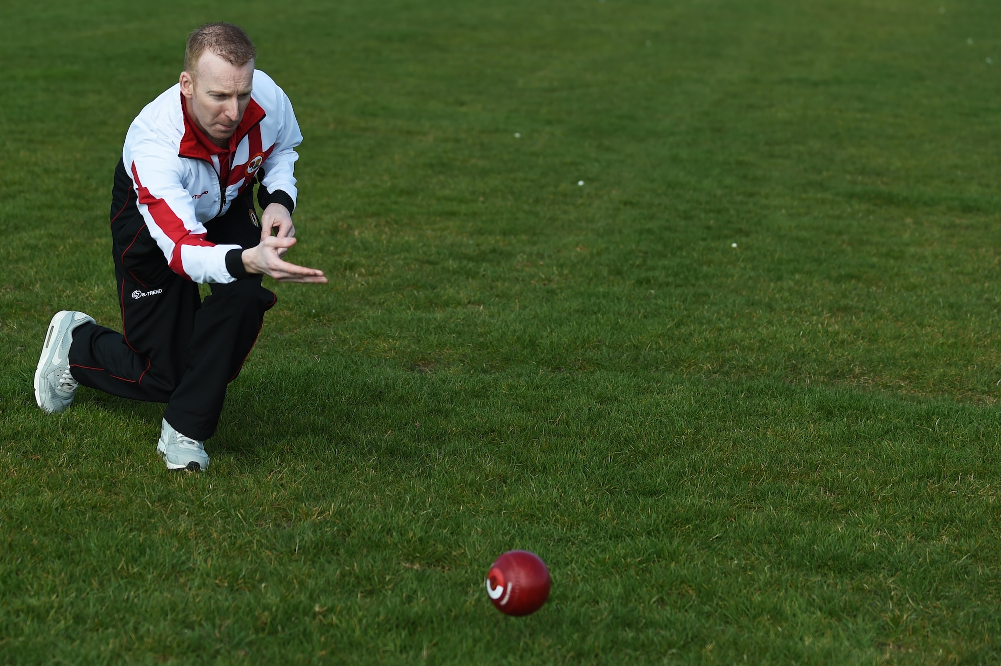 Nick Brett, 423rd Civil Engineer Squadron water and fuels shop chief, rolls a bowl along the athletic field at RAF Alconbury, England, March 23, 2015. Known as “The Ginger Ninja,” Brett, the current world indoor bowls champion, said he prefers a more aggressive bowling style than most of his fellow players. (U.S. Air Force photo by Staff Sgt. Jarad A. Denton/Released)
