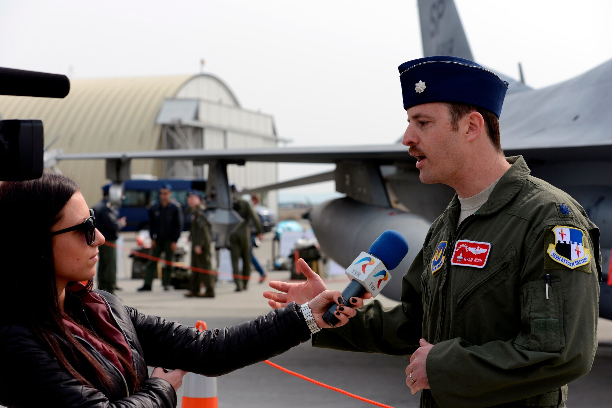 A Romanian media member asks Lt. Col. Ryan Nudi, 52nd Fighter Wing chief of safety, about the combined U.S. and Romanian fighter pilot training at Campia Turzii, Romania, during Dacian Warhawk, March 22, 2015. More than 20 local and national Romanian media members were invited to witness the accomplishments of the Dacian Warhawk mission, a two-week training event designed to increase the interoperability between the two nations. (U.S. Air Force photo/Staff Sgt. Kris Levasseur)