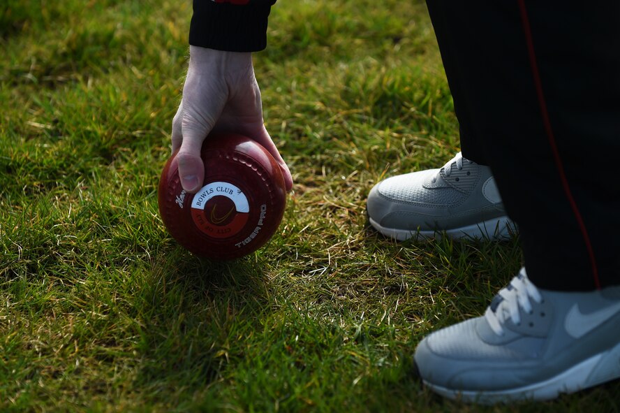 Nick Brett, 423rd Civil Engineer Squadron water and fuels shop chief, picks up a bowl from the athletic field at RAF Alconbury, England, March 23, 2015. Brett, who has played Bowls for more than 28 years, recently won the title of world champion indoor bowler. (U.S. Air Force photo by Staff Sgt. Jarad A. Denton/Released)