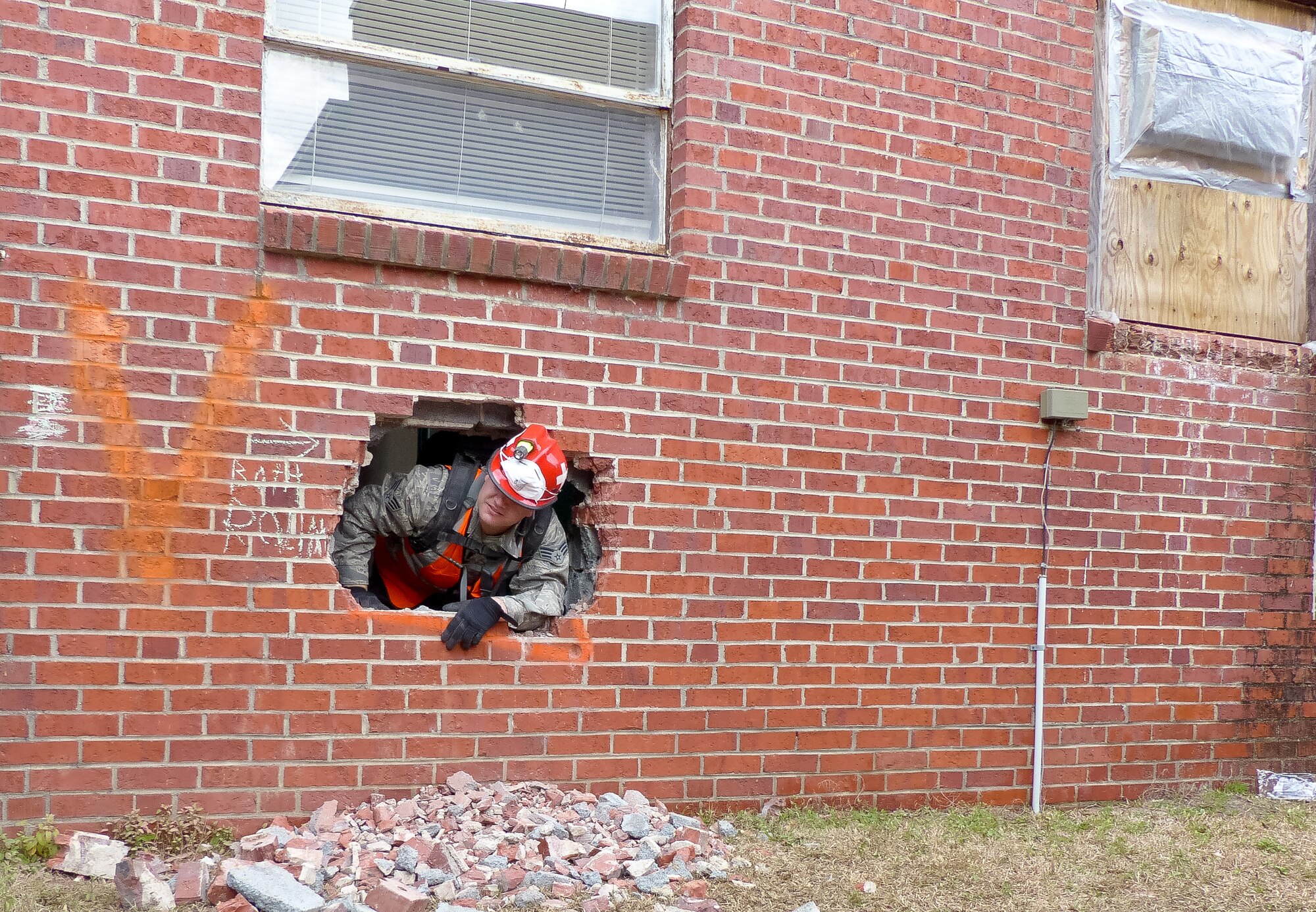 U.S. Air Force Senior Airman Luis J. Barragan a search and extraction medic with the 116th Medical Group, Air National Guard, communicates that the area has been cleared of all simulated victims during Exercise Vigilant Guard 2015, Georgetown, S.C., March 11, 2015.  Vigilant Guard is a series of federally funded disaster-response drills conducted by National Guard units working with federal, state and local emergency management agencies and first responders. (U.S. Air National Guard photo contributed/Released)