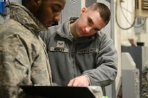 Senior Airman Corbin Worley, 91st Missile Operations Squadron facility maintenance team instructor, goes over technical orders with Senior Airman Darius Robinson, 91st MOS FMT member, during training on Minot Air Force Base, N.D., March 3, 2015. To become a FMT instructor, one must be 100 percent certified on trainable tasks and attend the 20th Air Force Intercontinental Ballistic Missile Maintenance Instructional Course. (U.S. Air Force photo/Senior Airman Brittany Y. Bateman)