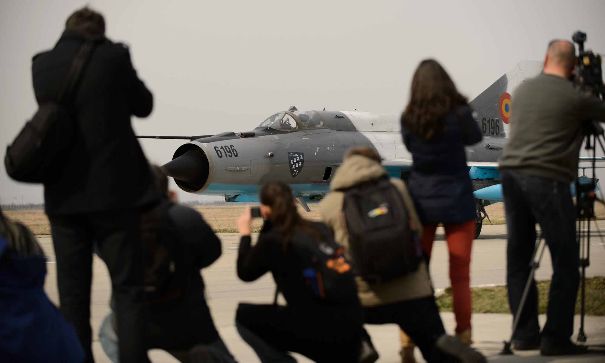 Members of local and national media photograph a Romanian MiG-21 at Campia Turzii, Romania, March 22, 2015. U.S. and Romanian Airmen hosted a media and distinguished visitor day in order to showcase the efforts during Dacian Warhawk, a two-week training mission designed to increase the interoperability between the two nations. (U.S. Air Force photo/Staff Sgt. Armando A. Schwier-Morales)