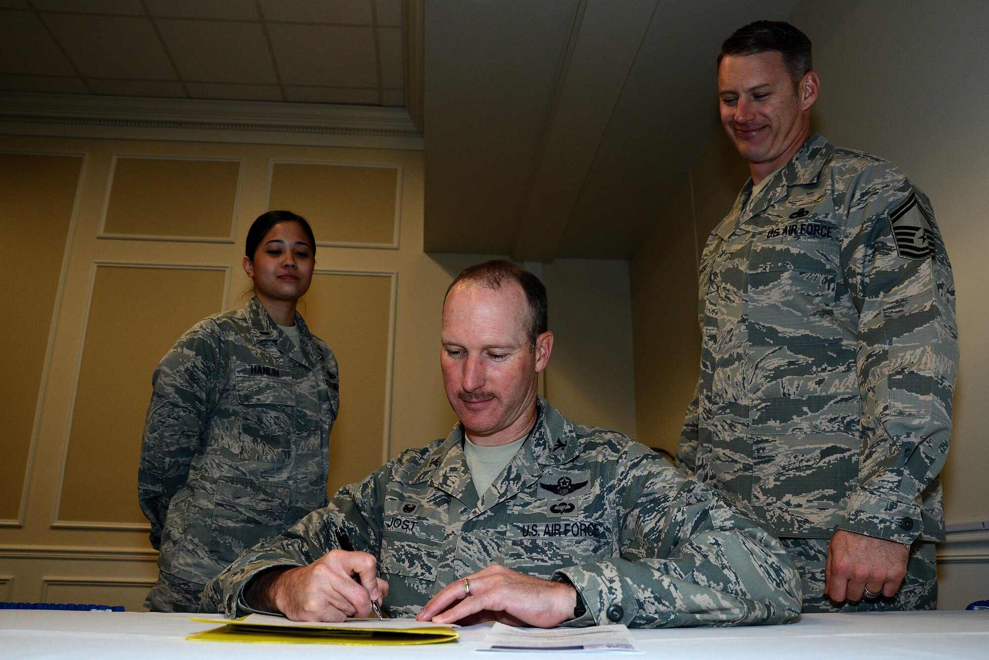 U.S. Air Force Col. Stephen Jost, 20th Fighter Wing commander, signs a contribution form to signify the start of the 2015 Air Force Assistance Fund campaign at Shaw Air Force Base, S.C., March 19, 2015. In 2014, the Air Force Aid Society gave out $250,000 in grants and loans to Shaw Airmen. (U.S. Air Force photo by Airman 1st Class Michael Cossaboom/Released)