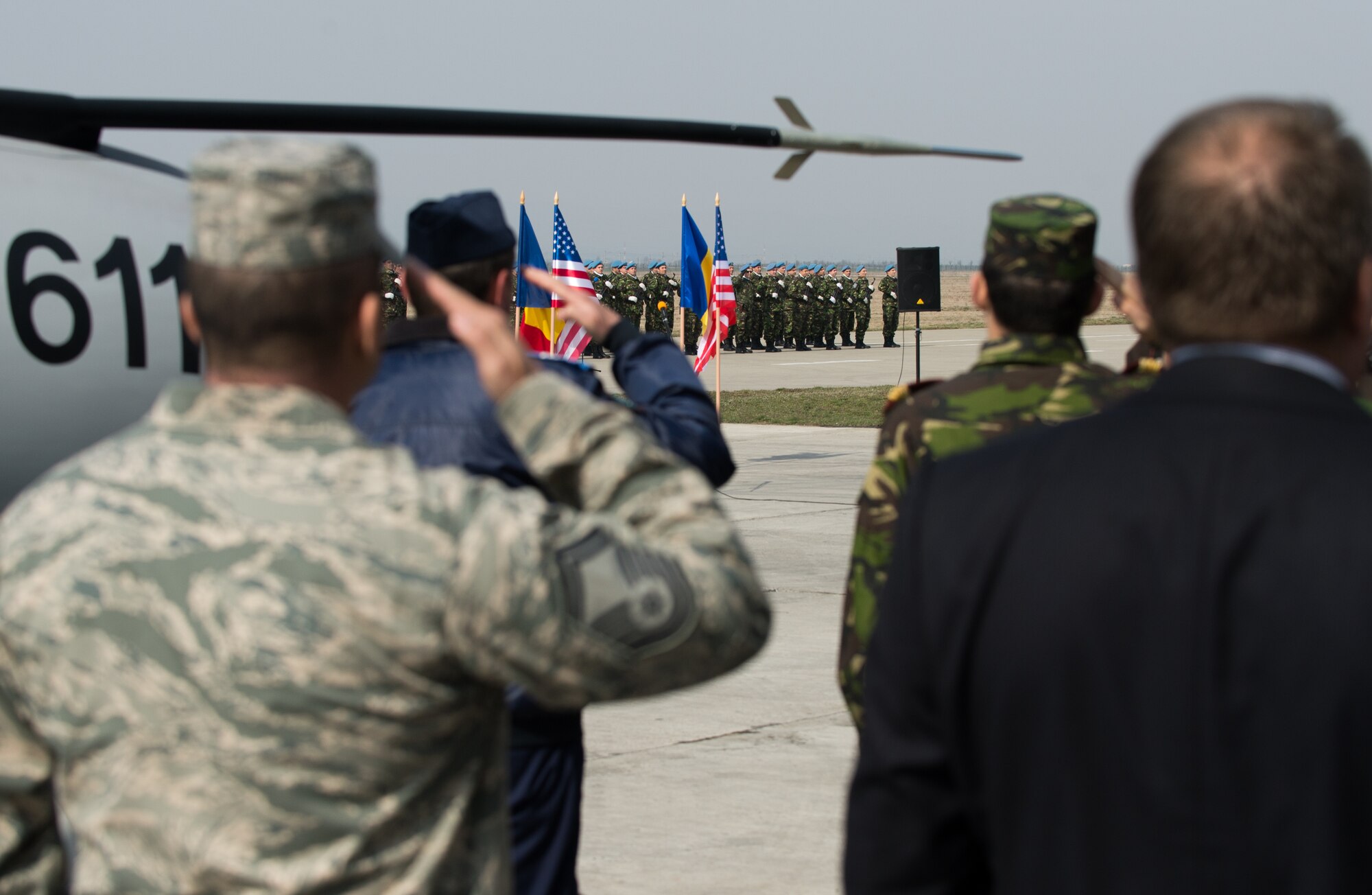 Airmen from U.S. and Romania salute as the national anthems play during a media and distinguished visitor day at Campia Turzii, Romania, March 22, 2015. More than 20 local and national Romanian media personnel view the accomplishments of the Dacian Warhawk mission, a two-week training mission designed to increase the interoperability between the two nations. (U.S. Air Force photo/Staff Sgt. Armando A. Schwier-Morales)
