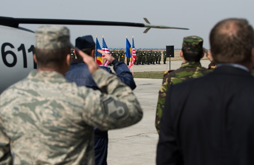 Airmen from U.S. and Romania salute as the national anthems play during a media and distinguished visitor day at Campia Turzii, Romania, March 22, 2015. More than 20 local and national Romanian media personnel view the accomplishments of the Dacian Warhawk mission, a two-week training mission designed to increase the interoperability between the two nations. (U.S. Air Force photo/Staff Sgt. Armando A. Schwier-Morales)