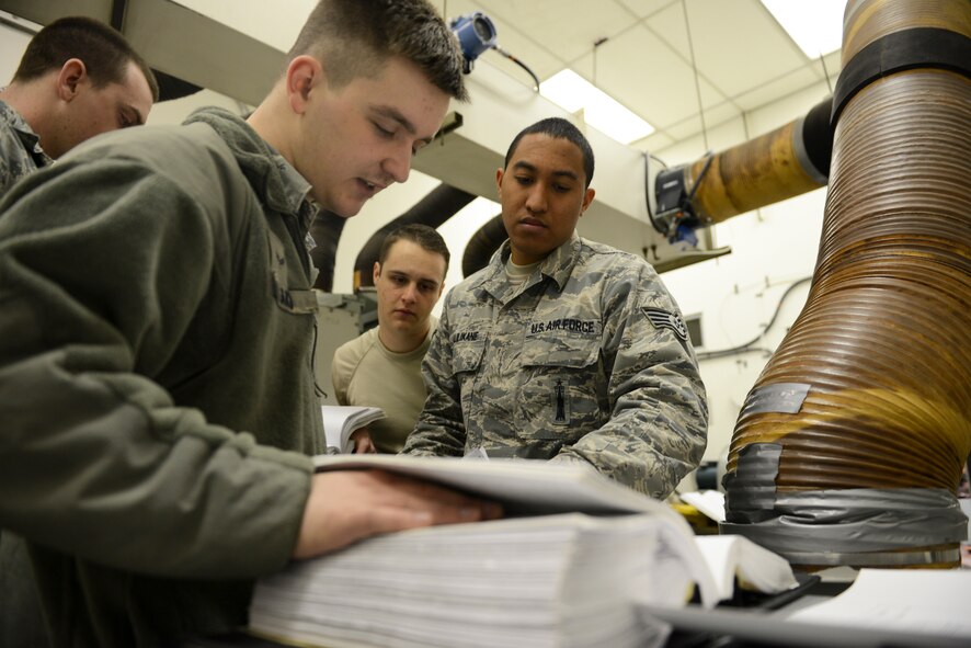 Staff Sgt. Kamuela Kalilikane, 91st Missile Operations Squadron facilities maintenance team training instructor, goes through technical orders with his students during training on Minot Air Force Base, N.D., March 3, 2015. FMT instructors provide instruction to produce competent facilities maintenance technicians that are able to perform periodic maintenance, troubleshoot, and repair diesel-electrical units and environmental control systems that sustain unmanned launch facilities. (U.S. Air Force photo/Senior Airman Brittany Y. Bateman)