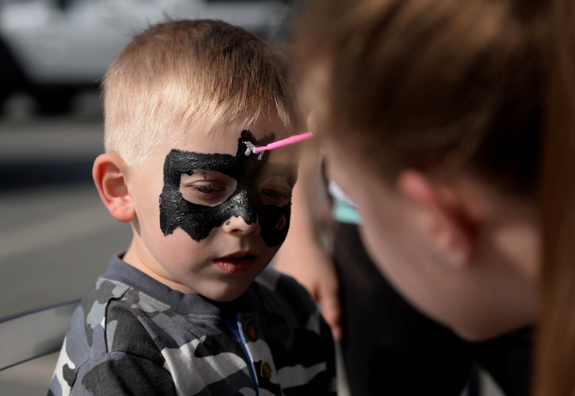 Jacob Stegall, child of Amie Stegall and U.S Air Force Tech Sgt. Robert Stegall, 52nd Logistics Readiness Squadron, receives face paint during the Exceptional Family Member Program Spring Fling at the Base Exchange at Spangdahlem Air Base, March 20, 2015. The Airman & Family Readiness Center hosted the event to raise awareness of the EFMP and the service it provides for families. Members of the base community volunteered to run various activities to ensure family members could experience the fair’s full potential. (U.S. Air Force photo by Airman 1st Class Timothy Kim/Released)