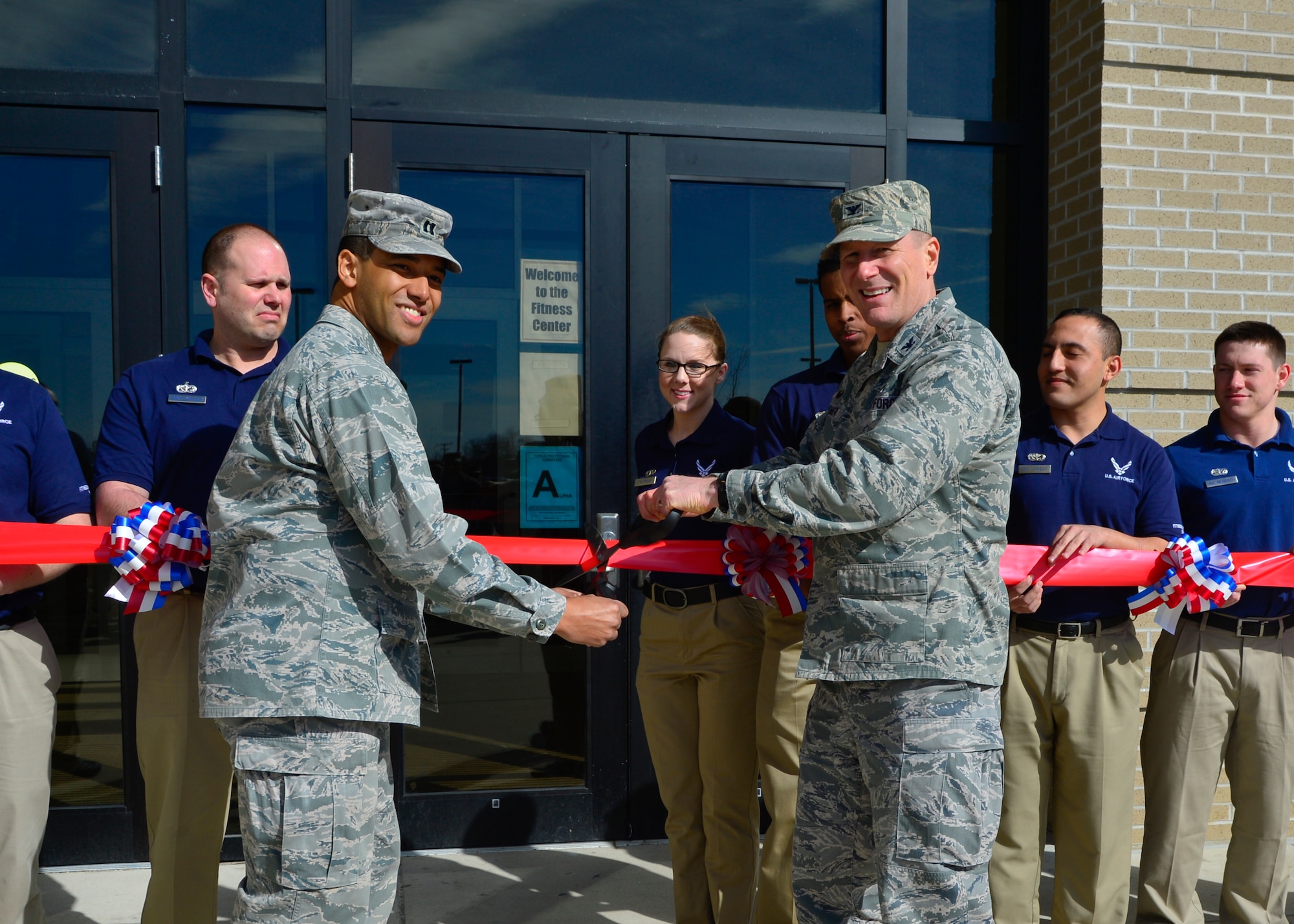 Col. Michael Grismer, 436th Airlift Wing commander, and Capt. Walter Wingard, Jr., 436th Force Support Squadron Sustainment Flight commander, cut the ribbon for the new fitness center’s 24-hour, seven days per week schedule March 18, 2015, at Dover Air Force Base, Del. The new 24/7 policy allows Department of Defense Common Access Card (CAC) holders to enter the facility after normal operating hours. (U.S. Air Force photo/Airman 1st Class William Johnson)