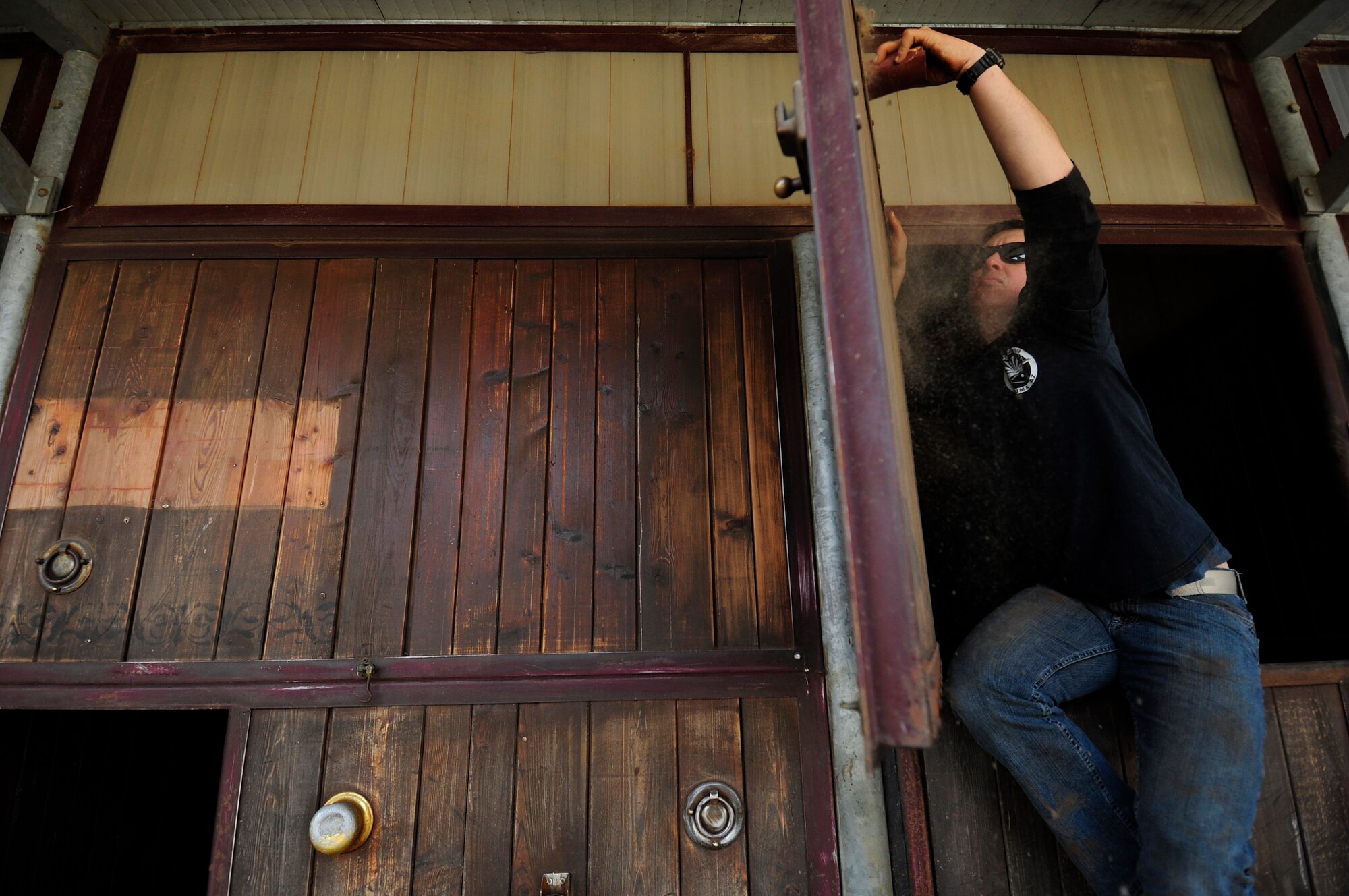 U.S. Air Force Staff Sgt. Cody Sapp, 31st Maintenance Squadron crew chief, sands down a horse stall before painting it March, 15, 2015 in Porcia, Italy. A group of more than 10 Airmen volunteered to help a local a therapeutic horse-riding center. The center helps children, teenagers and adults with motor, cognitive and emotional difficulties through horse therapy. (U.S. Air Force photo by Staff Sgt. Evelyn Chavez/Released)   