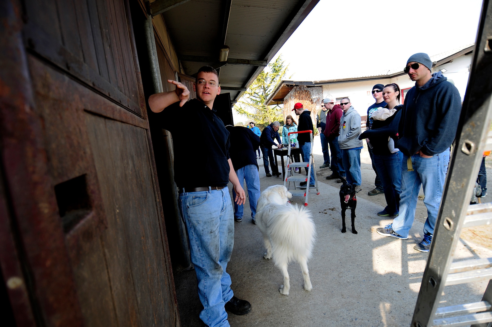 U.S. Air Force Staff Sgt. Andrew Beavers, 31st Aircraft Maintenance Squadron phase inspection section monitor, teaches volunteers how to strip paint from horse stalls March, 15, 2015 in Porcia, Italy. A group of more than 10 Airmen volunteered to help at a local therapeutic horse-riding center.  The center helps children, teenagers and adults with motor, cognitive and emotional difficulties through horse therapy. (U.S. Air Force photo by Staff Sgt. Evelyn Chavez/Released)   