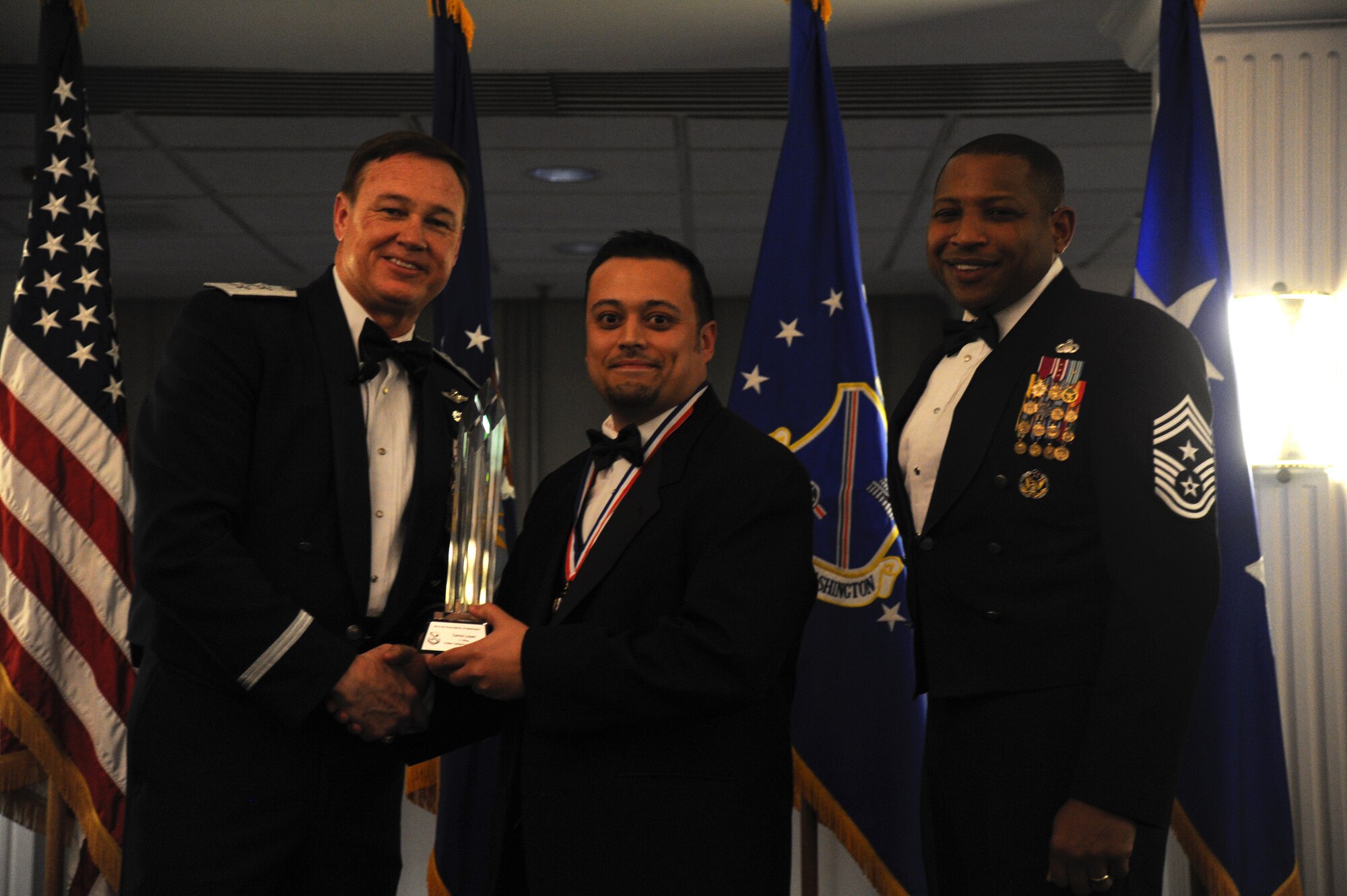Carlos Lopez, 11th Wing, accepts the 2014 Air Force District of Washington Annual Awards Civilian Category I of the Year trophy from AFDW Commander Maj. Gen. Darryl Burke and AFDW Command Chief Master Sgt. Farrell Thomas during the awards ceremony at Joint Base Anacostia-Bolling, D.C., March 20, 2015. (U.S. Air Force photo/Master Sgt. Tammie Moore)