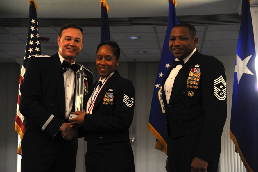 Tech. Sgt. Marshe Greene, 844th Communications Group, accepts the 2014 Air Force District of Washington Annual Awards Military Volunteer of the Year trophy from AFDW Commander Maj. Gen. Darryl Burke and AFDW Command Chief Master Sgt. Farrell Thomas during the awards ceremony at Joint Base Anacostia-Bolling, D.C., March 20, 2015. (U.S. Air Force photo/Master Sgt. Tammie Moore)